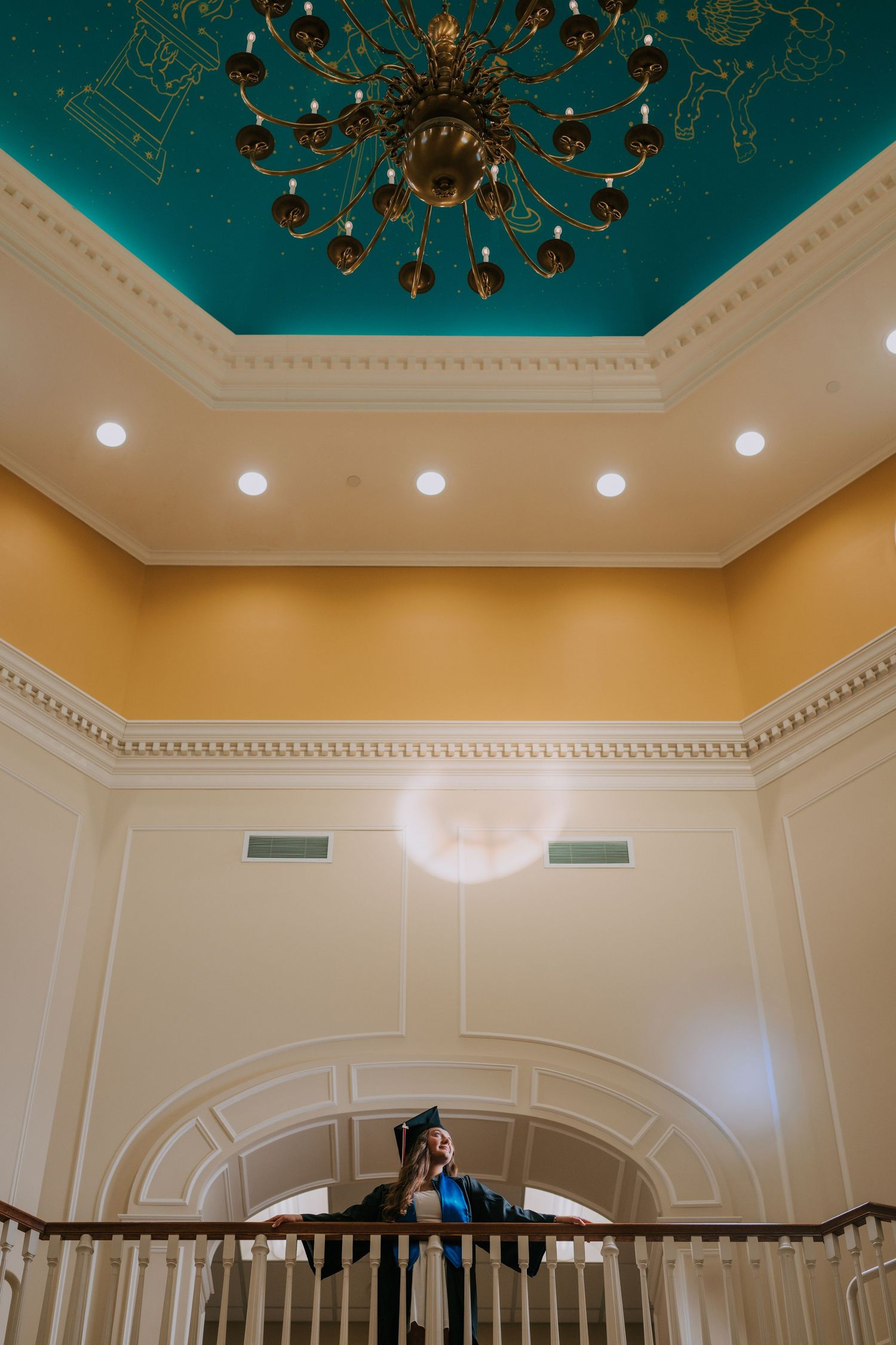 Elegant interior ceiling with ornate chandelier and architectural molding details.