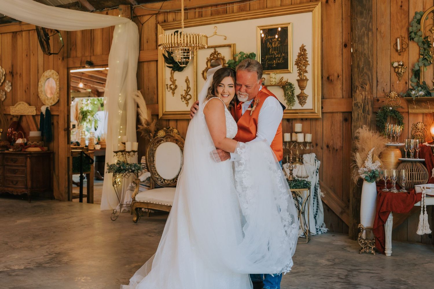 A couple shares their first dance in a rustic barn wedding venue.