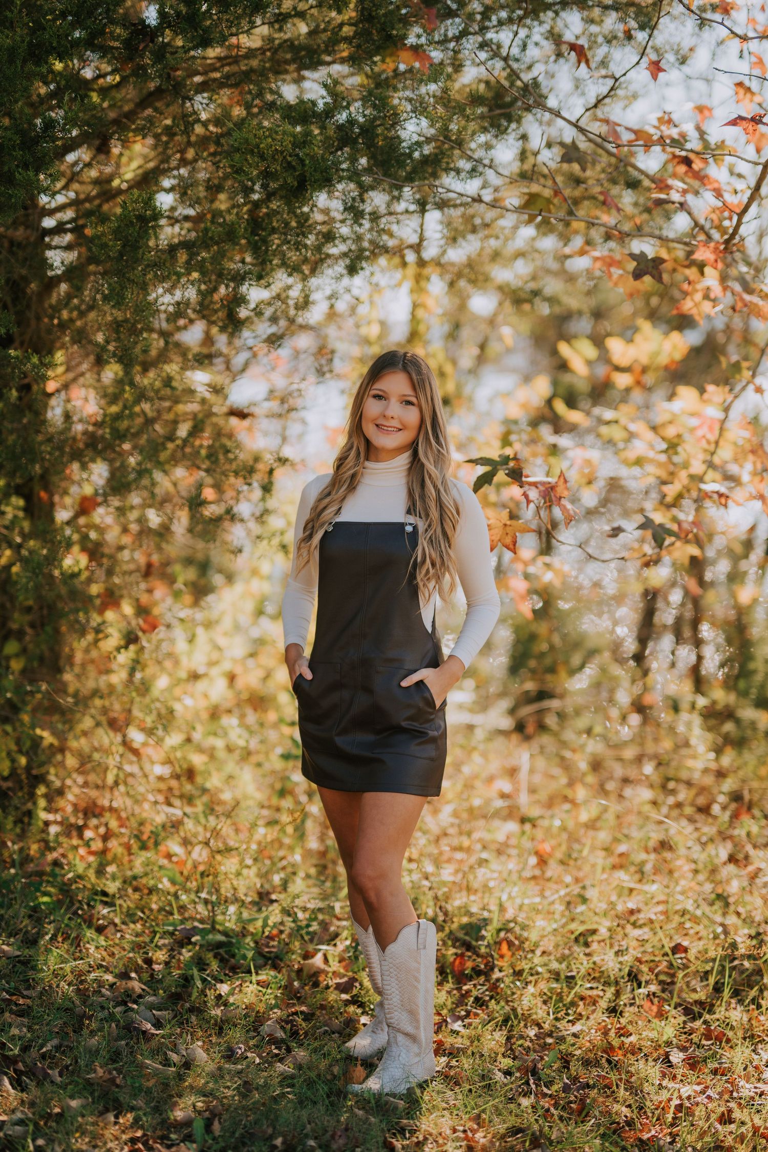 Autumn portrait session in a wooded area with golden sunlight filtering through leaves.