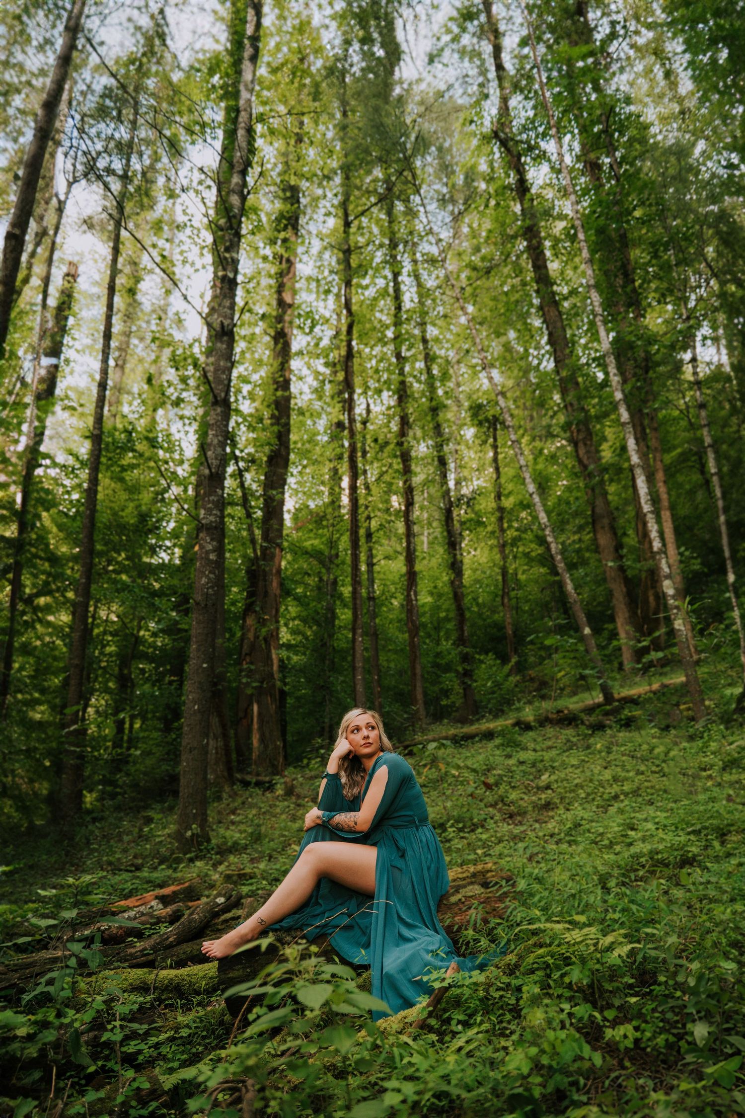 A series of artistic forest portraits featuring a teal dress against lush green woodland scenery.