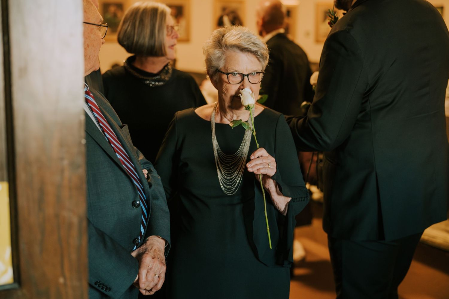 Group of wedding guests gathering in formal attire at an indoor church reception.