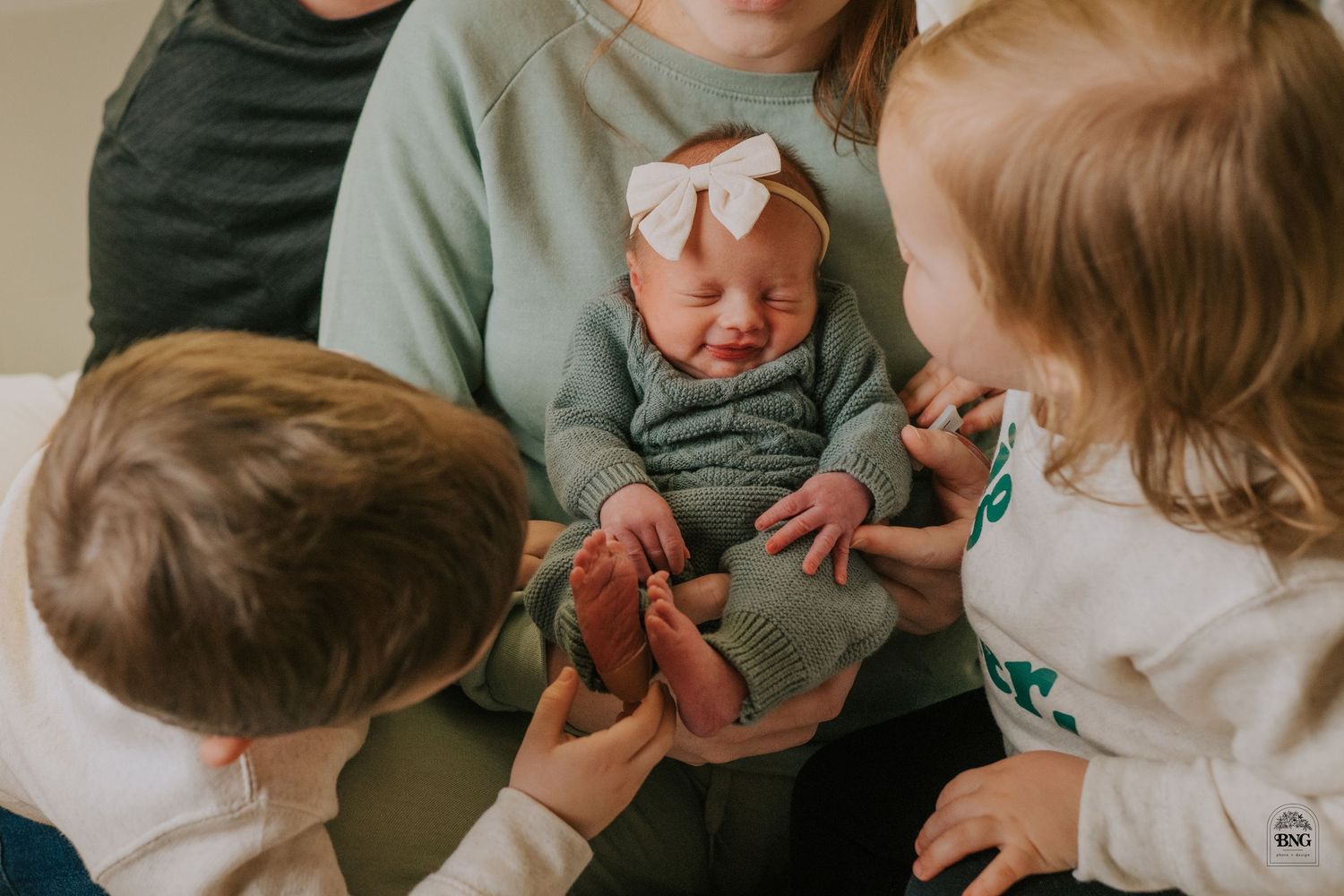 A series of intimate close-up shots showing tender moments with a baby wrapped in a white blanket.