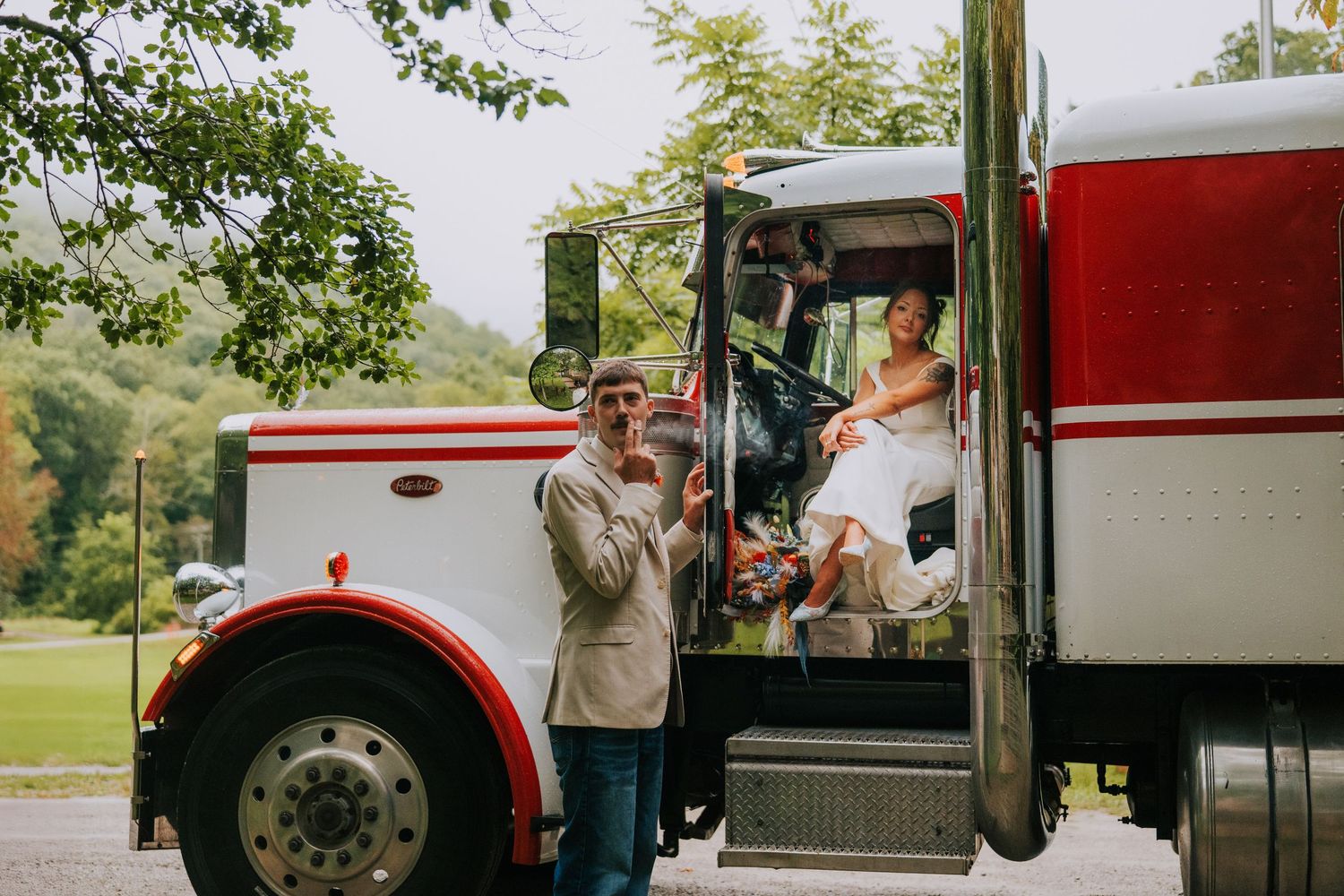A classic red and white truck parked outdoors during a wedding celebration.