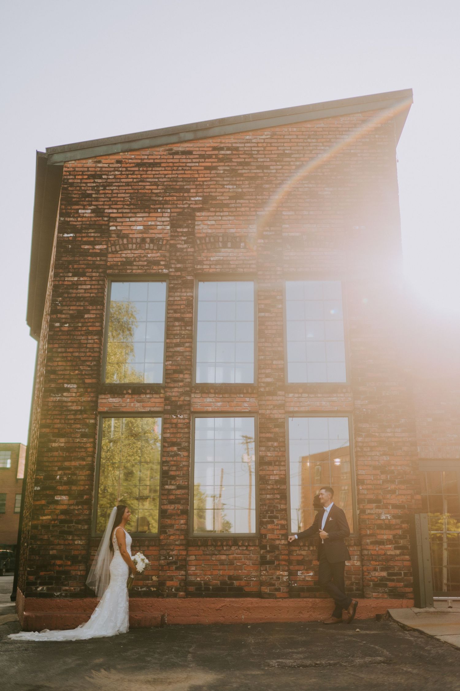 A romantic wedding photo sequence at sunset against a rustic brick building with warm golden light.