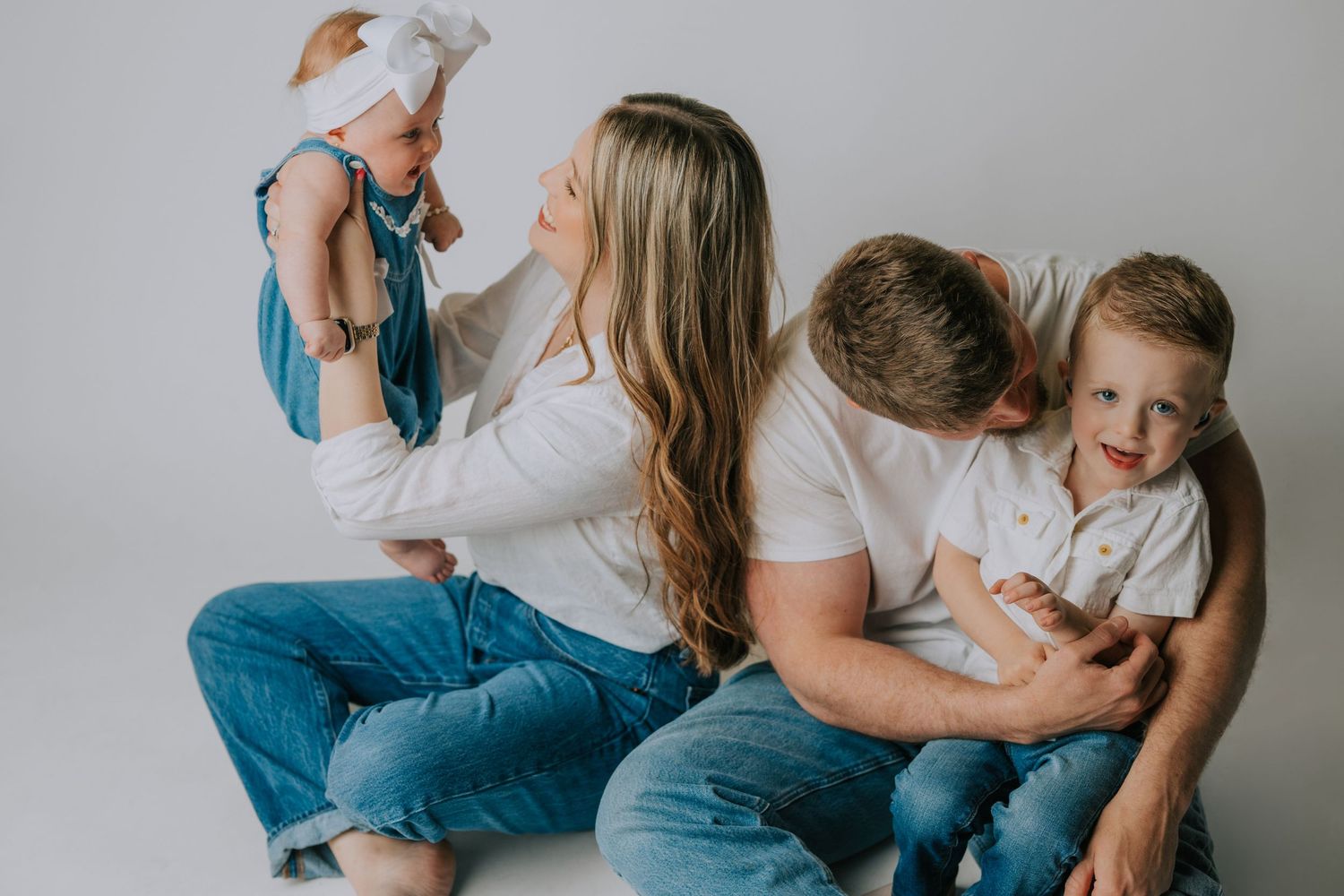 Casual family lifestyle session with playful moments on white background.