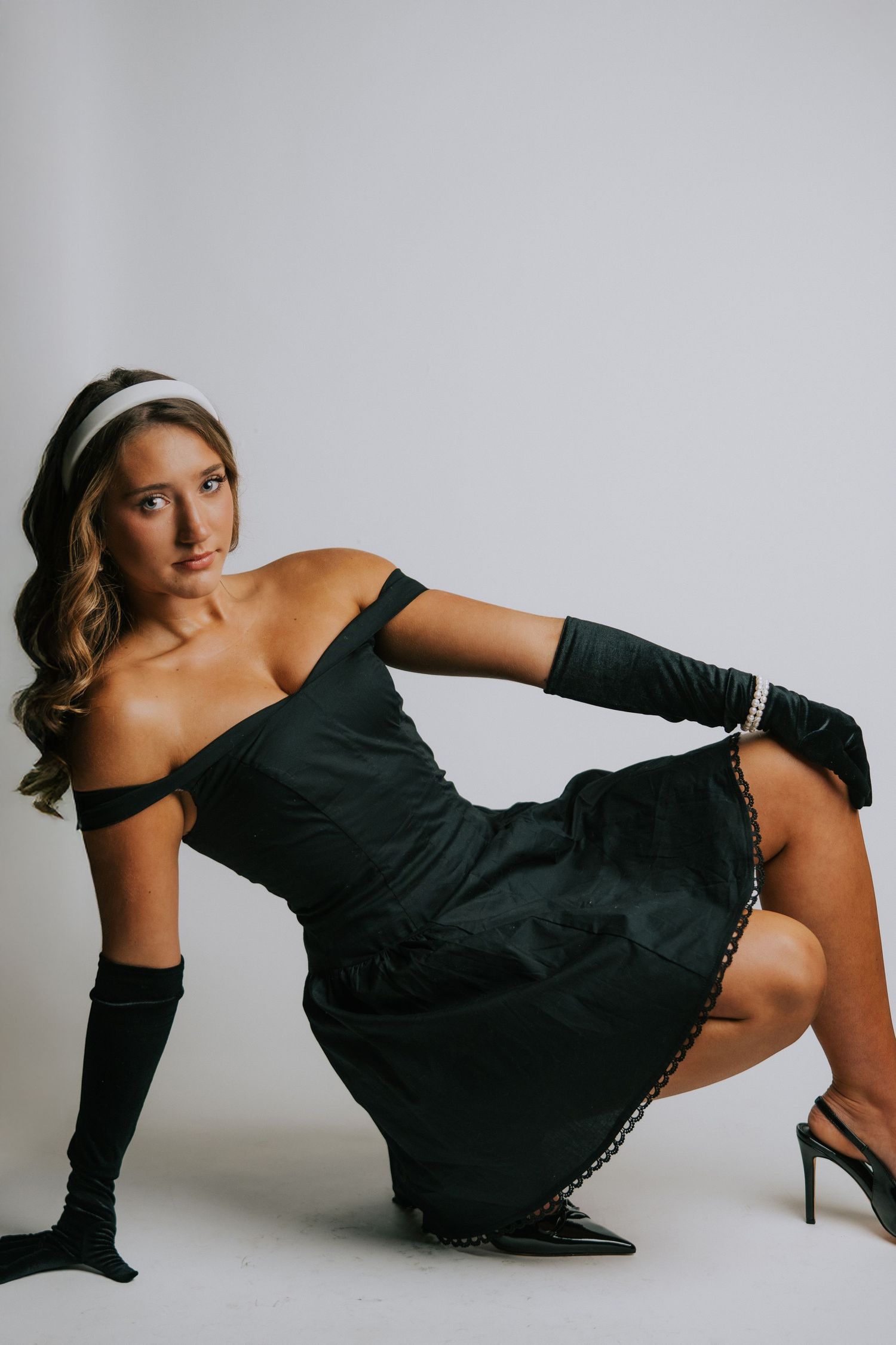 Fashion photo series in black dress and gloves on light studio background.