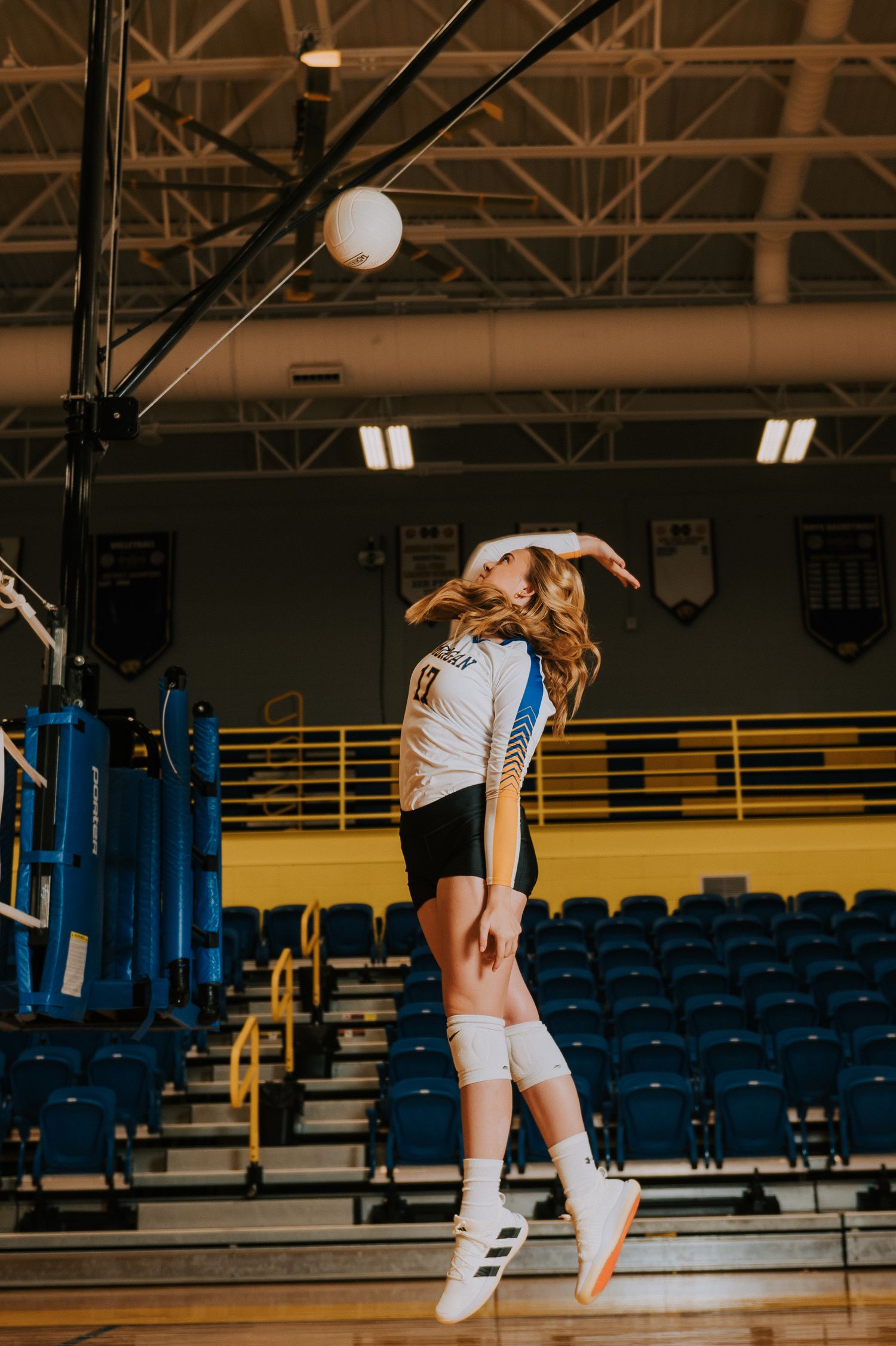Three connected photos show a volleyball player jumping to serve in an empty gymnasium with blue stadium seating.