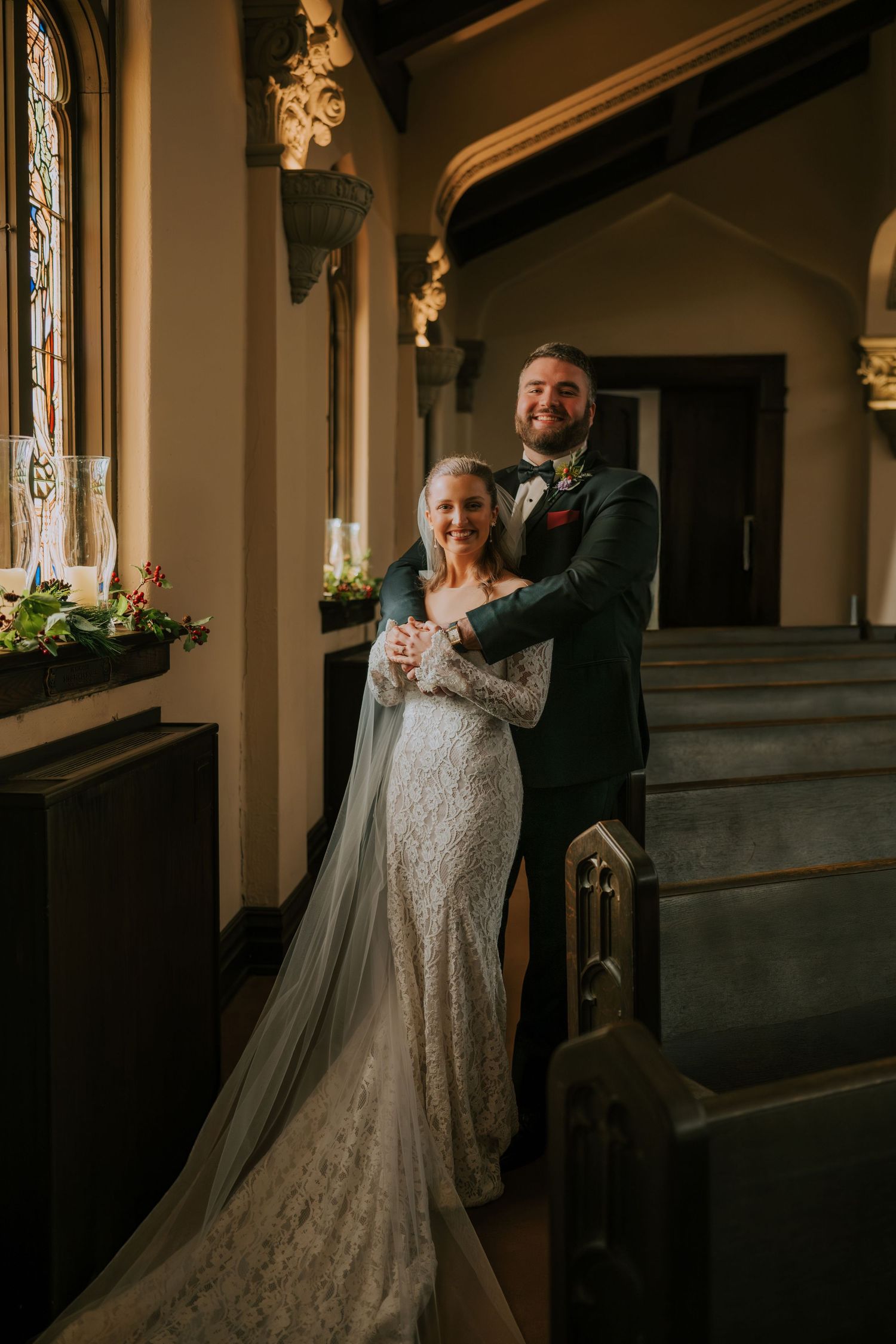 A romantic wedding photo featuring a lace gown and elegant interior with stained glass windows and architectural details.