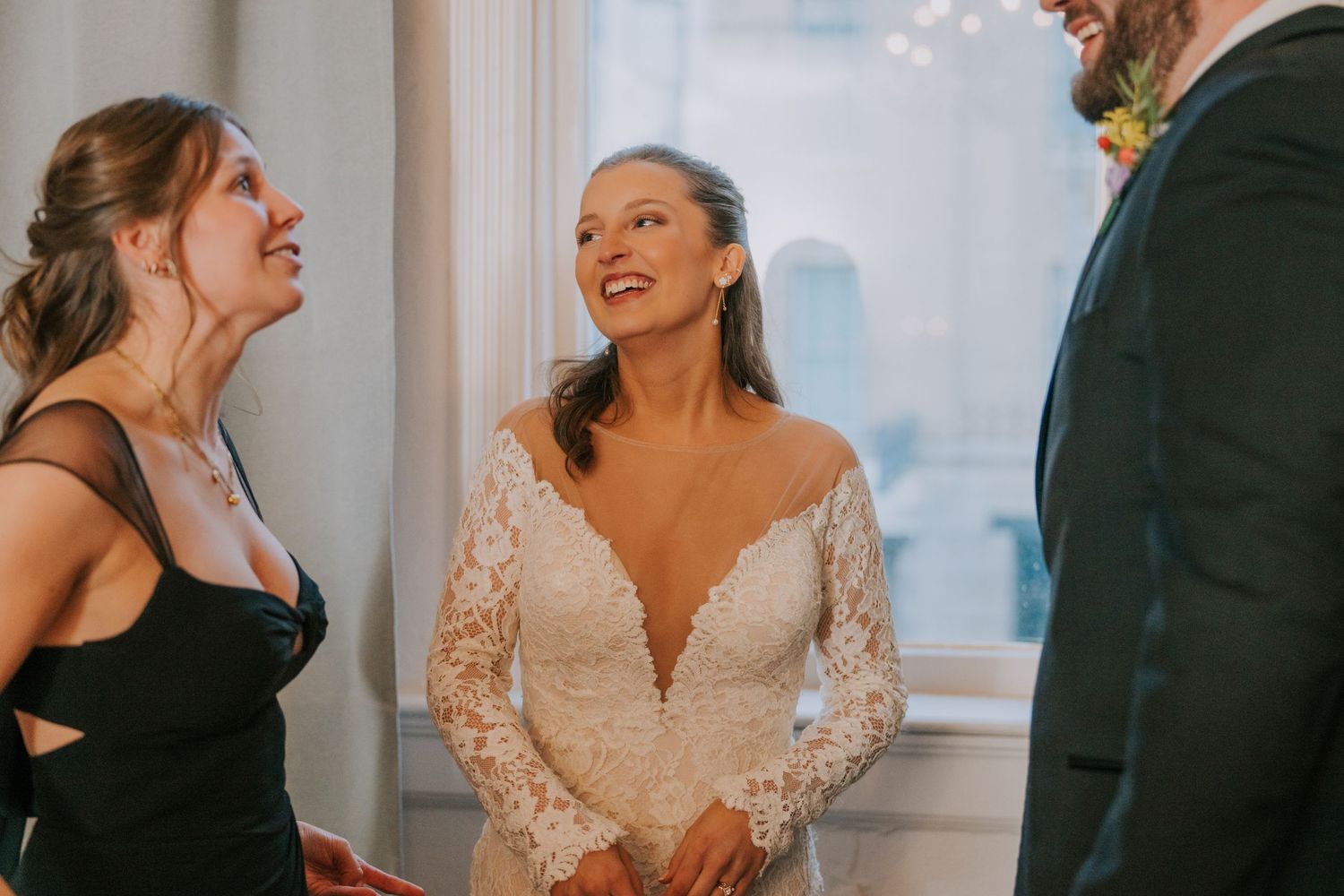 Candid moment of laughter shared between celebrants at an elegant indoor event.