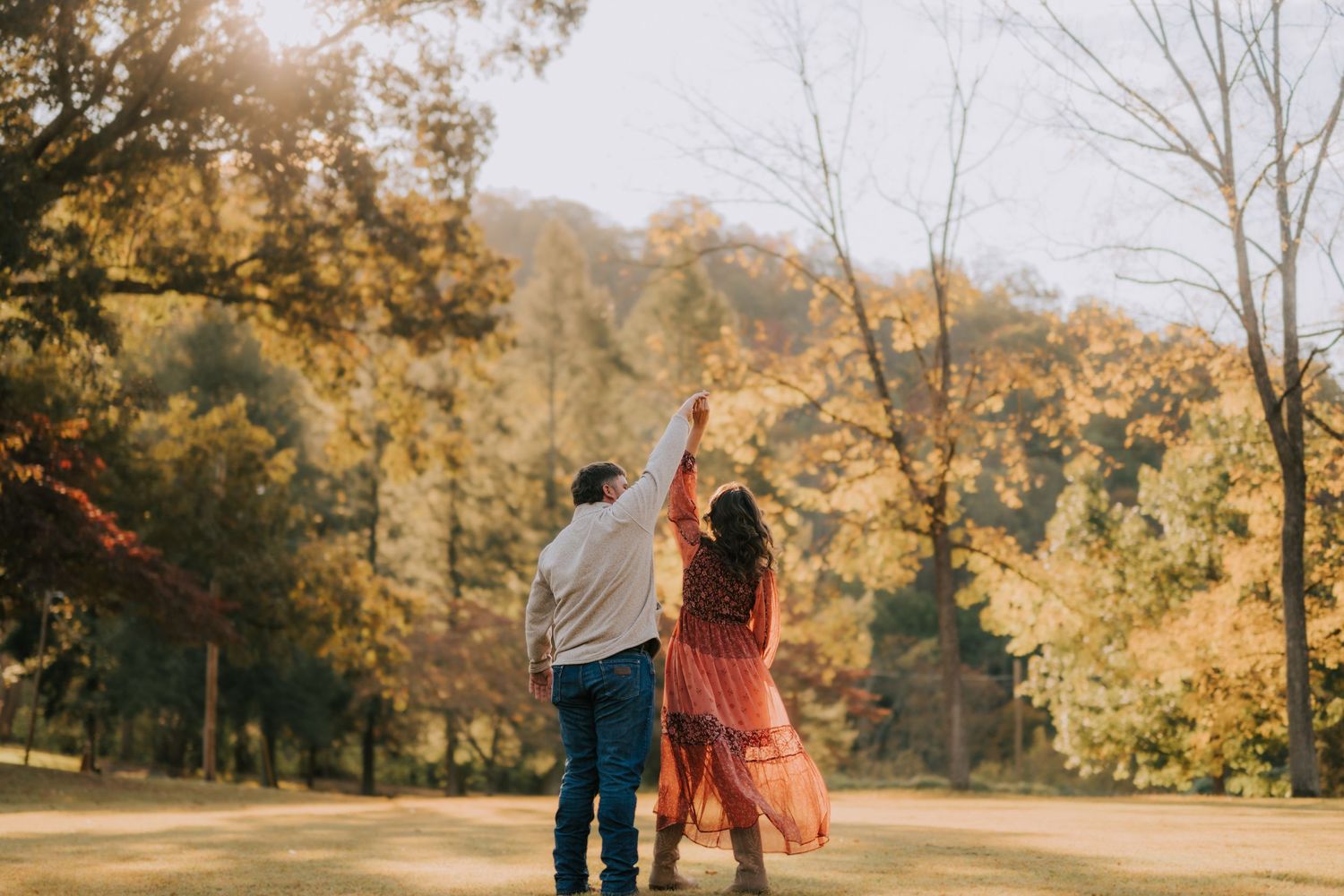 Golden sunlight streams through autumn trees during outdoor photo session.
