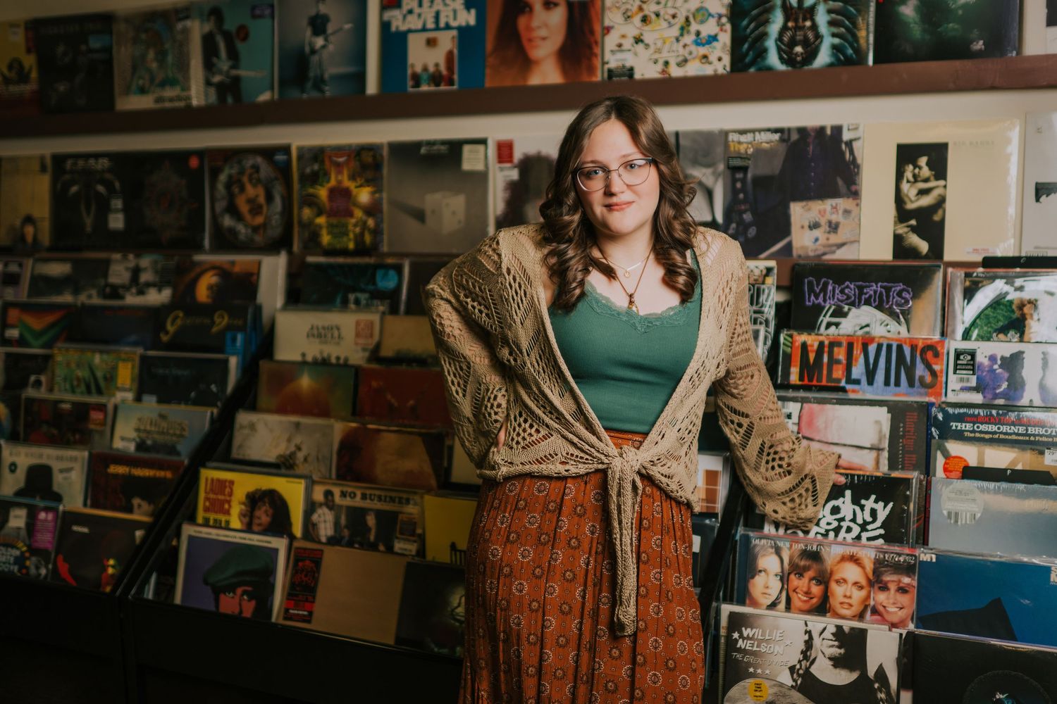 A vintage-inspired scene in a record store with vinyl albums displayed on the wall.
