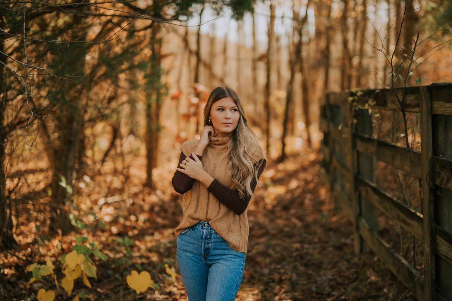 Outdoor autumn photography session among trees with golden afternoon light.
