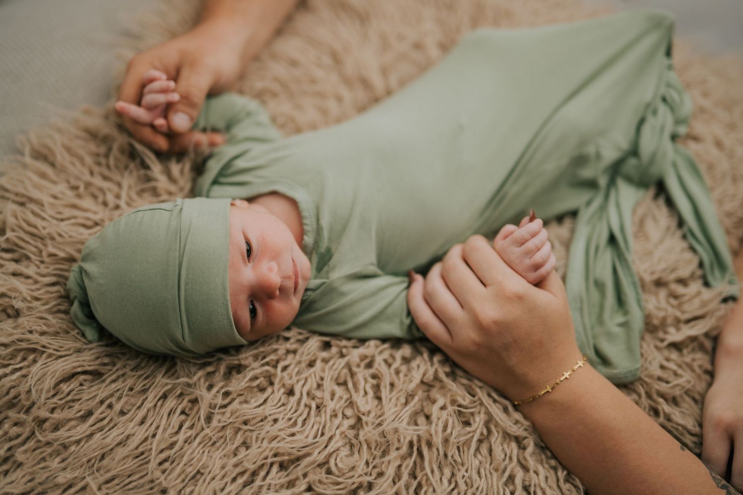Maternity photoshoot in a lush garden setting with a teal blue flowing dress.