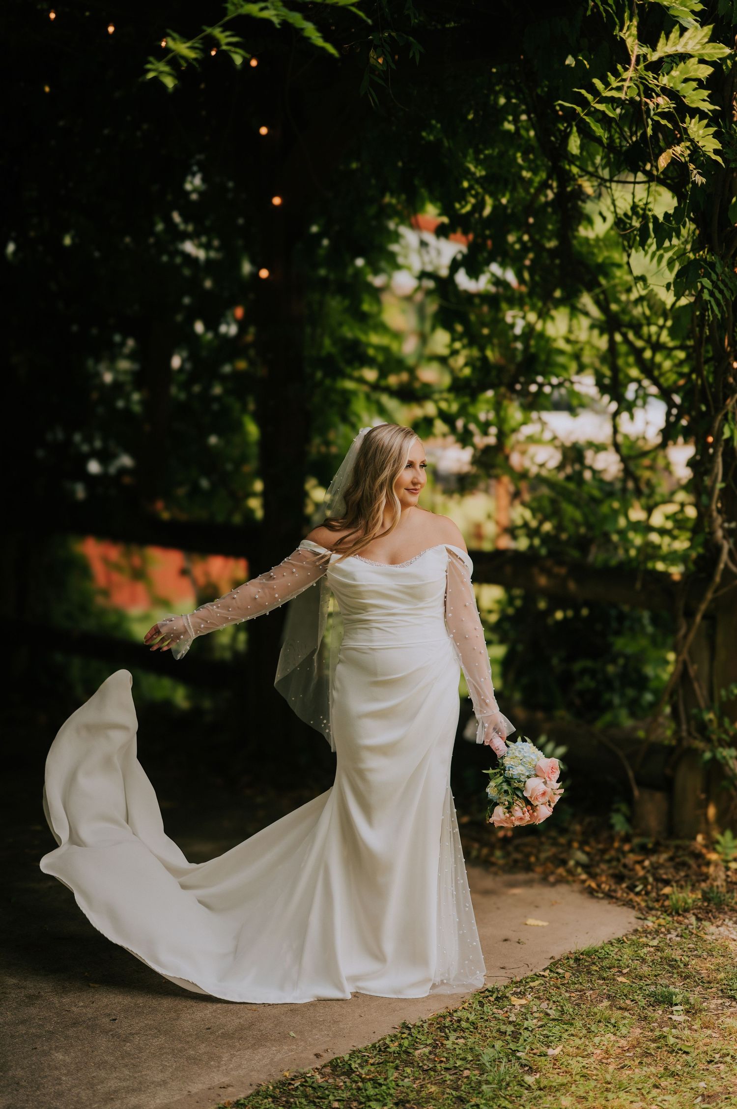 A white wedding dress flows gracefully in a series of outdoor shots against a natural green backdrop.