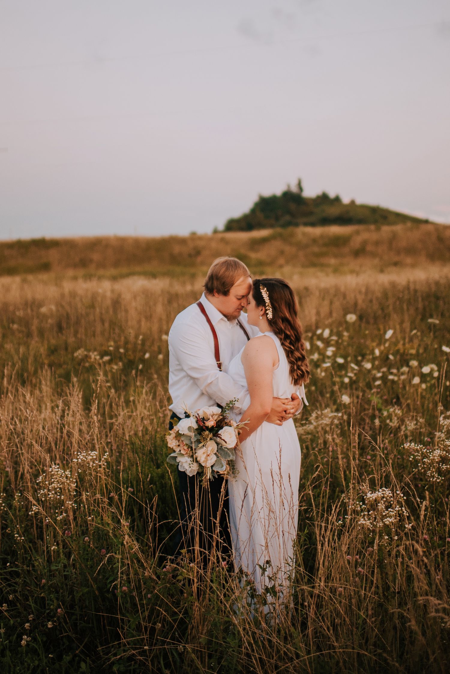 Romantic sunset wedding portraits in a wildflower field during golden hour.