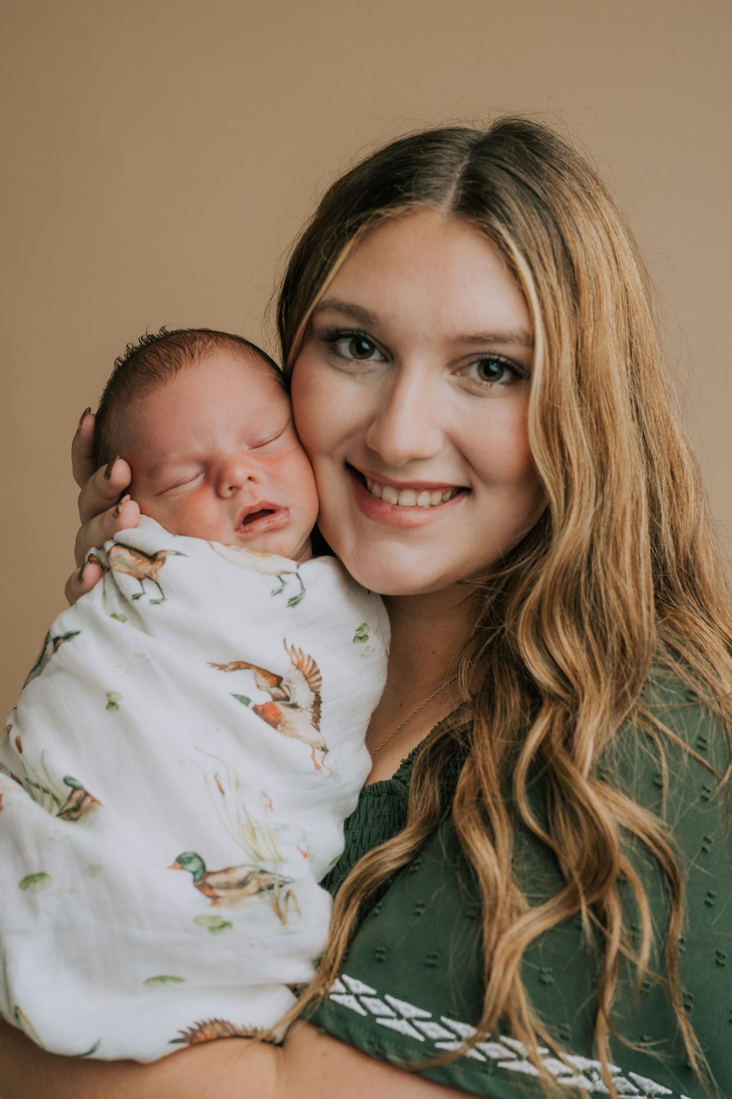 Sweet moment with infant wrapped in duck-print swaddle blanket.