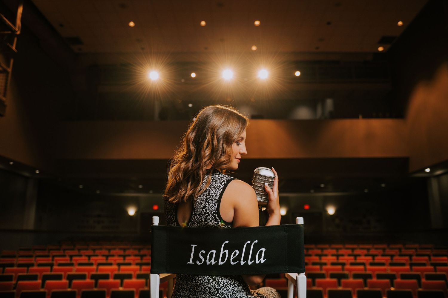 Theater or auditorium interior with dramatic lighting and red brick wall detail.