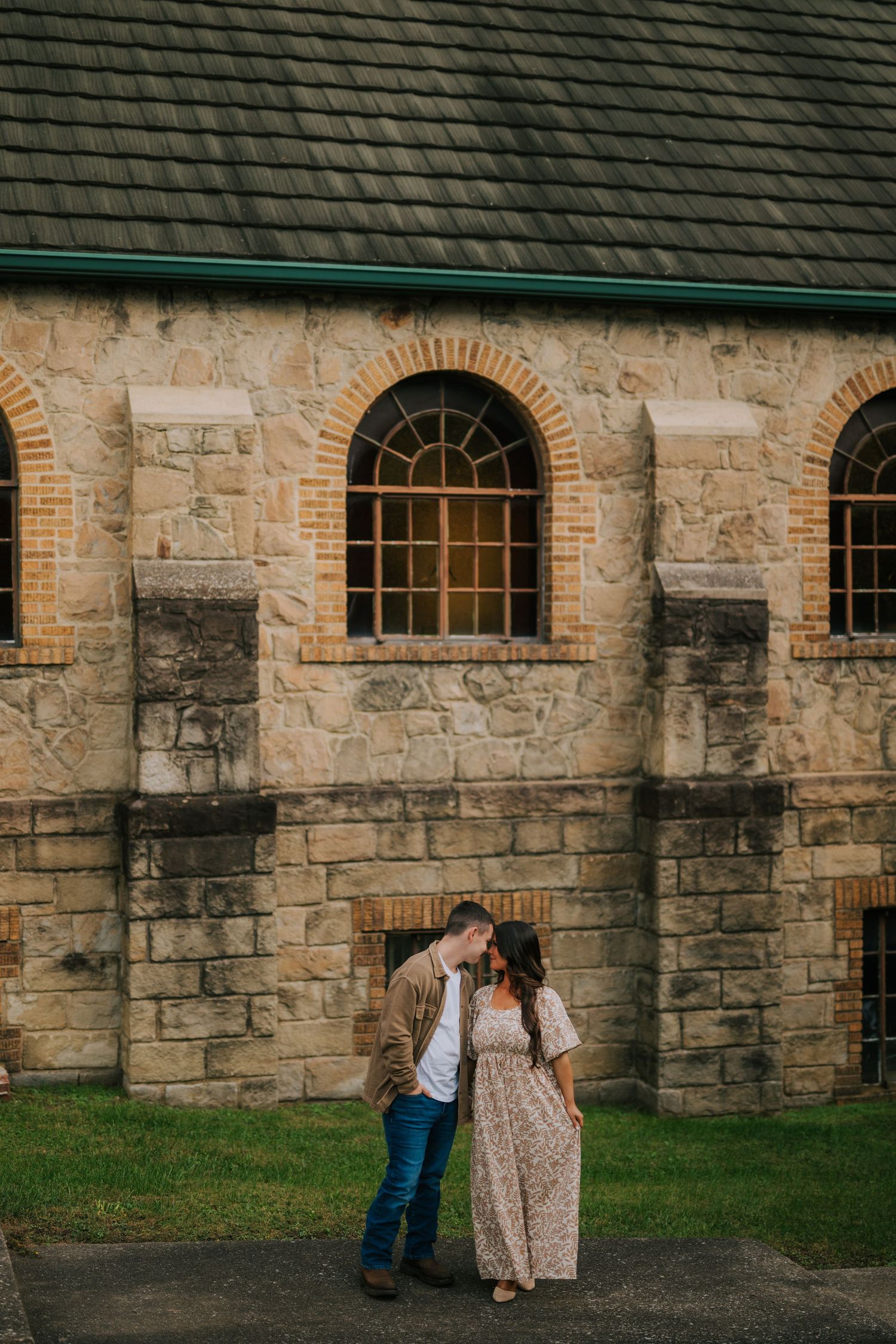 A romantic moment captured against the stone walls of a historic building.