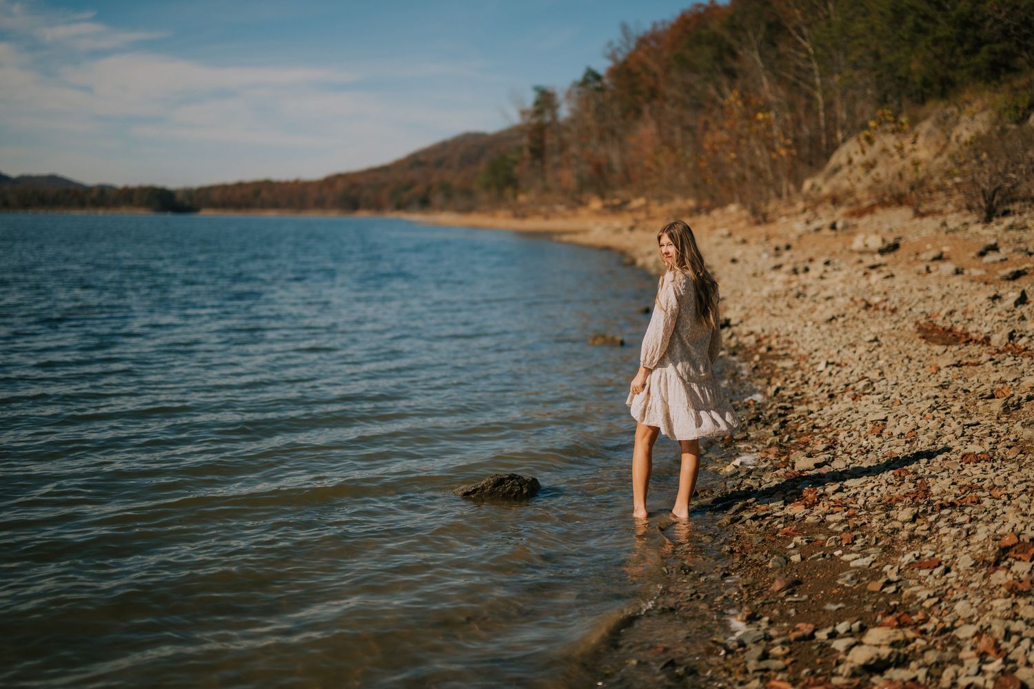 Natural waterfront setting with rocky shoreline and clear blue water.