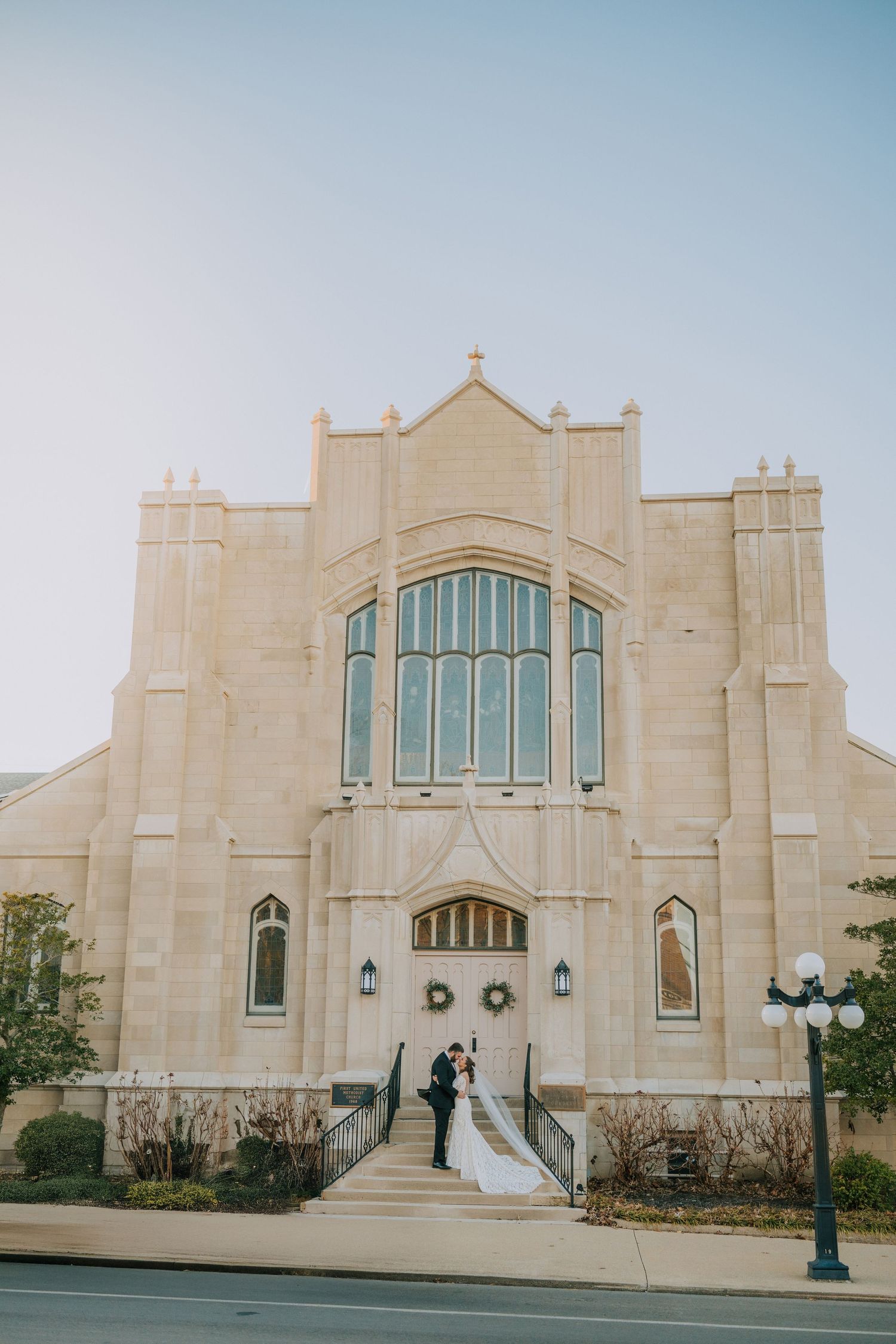 Exterior architectural view of modern stone church building with symmetrical design and steps.