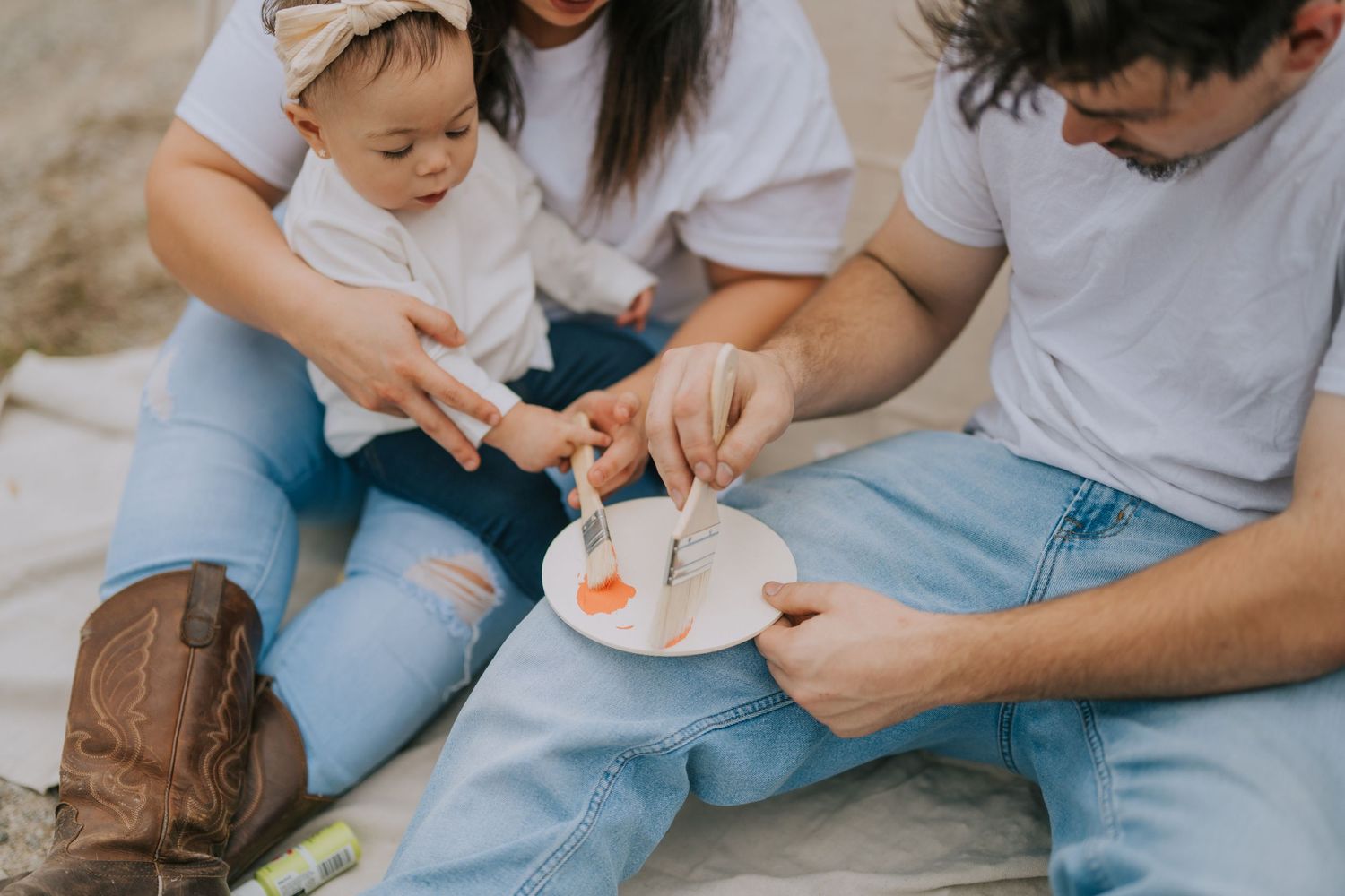 People in casual denim and white outfits sitting together during an outdoor photoshoot.