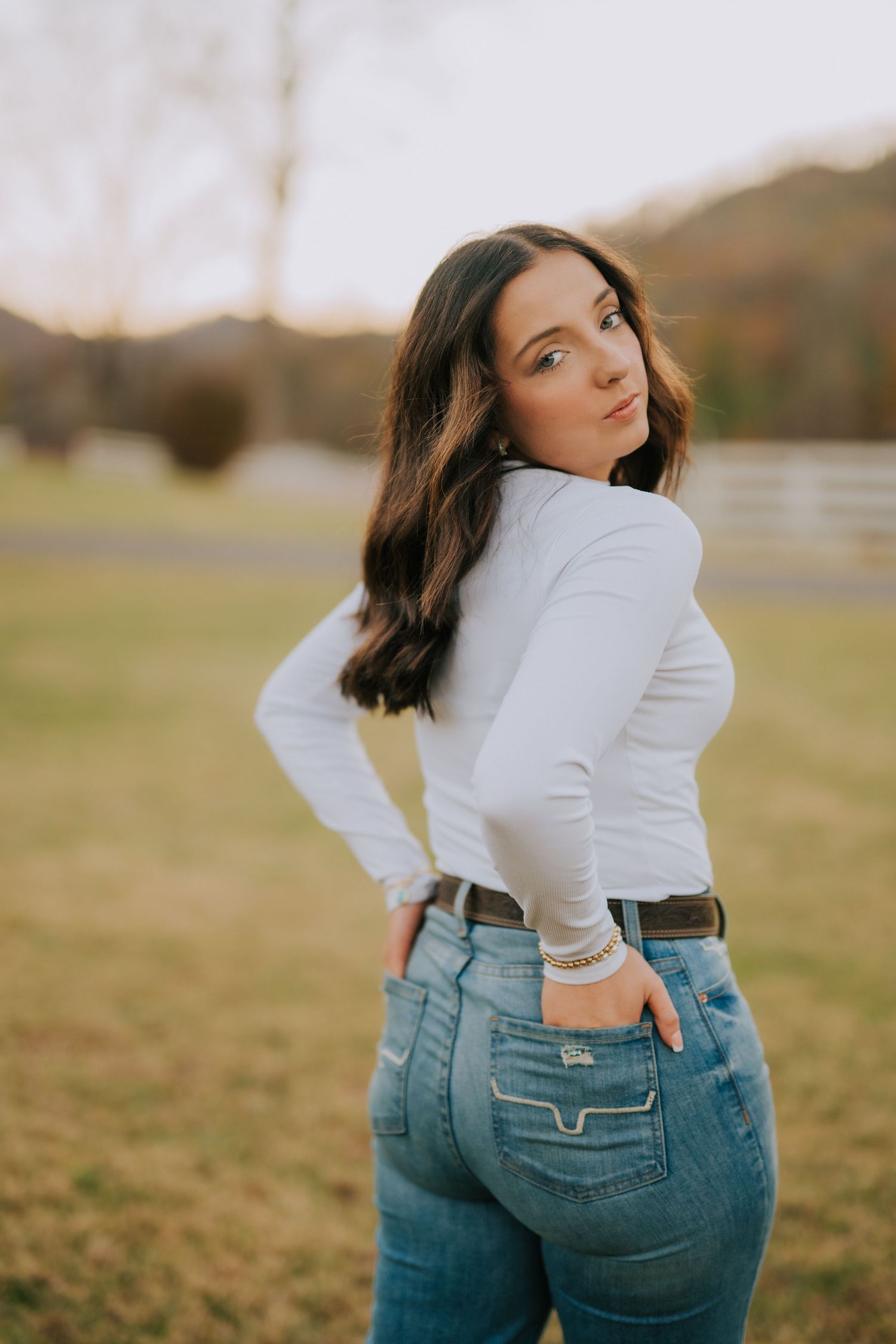 Series of artistic poses showcasing denim jeans against natural outdoor backdrop.