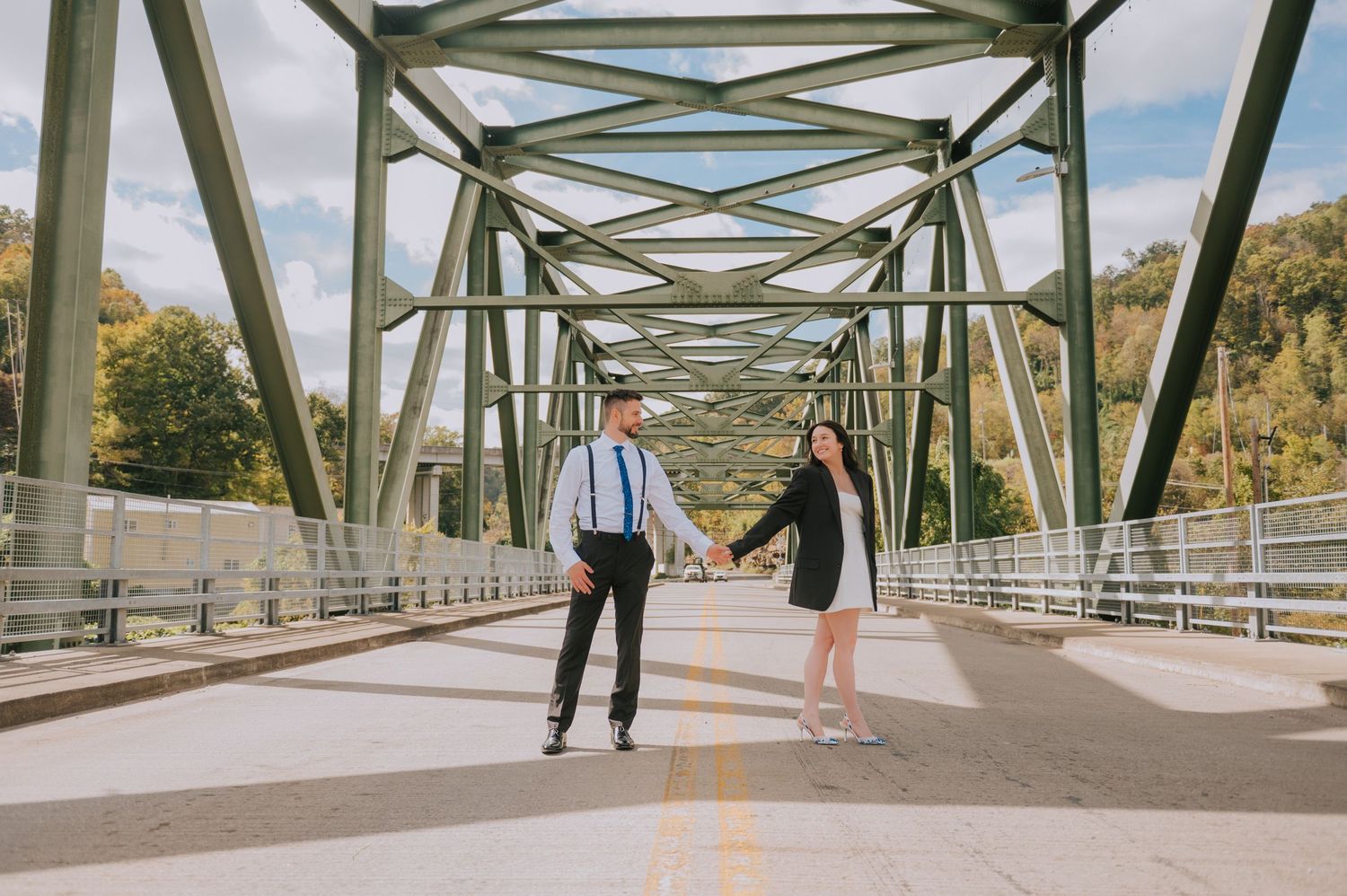 Long view of a metal bridge walkway with couple in formal wear.