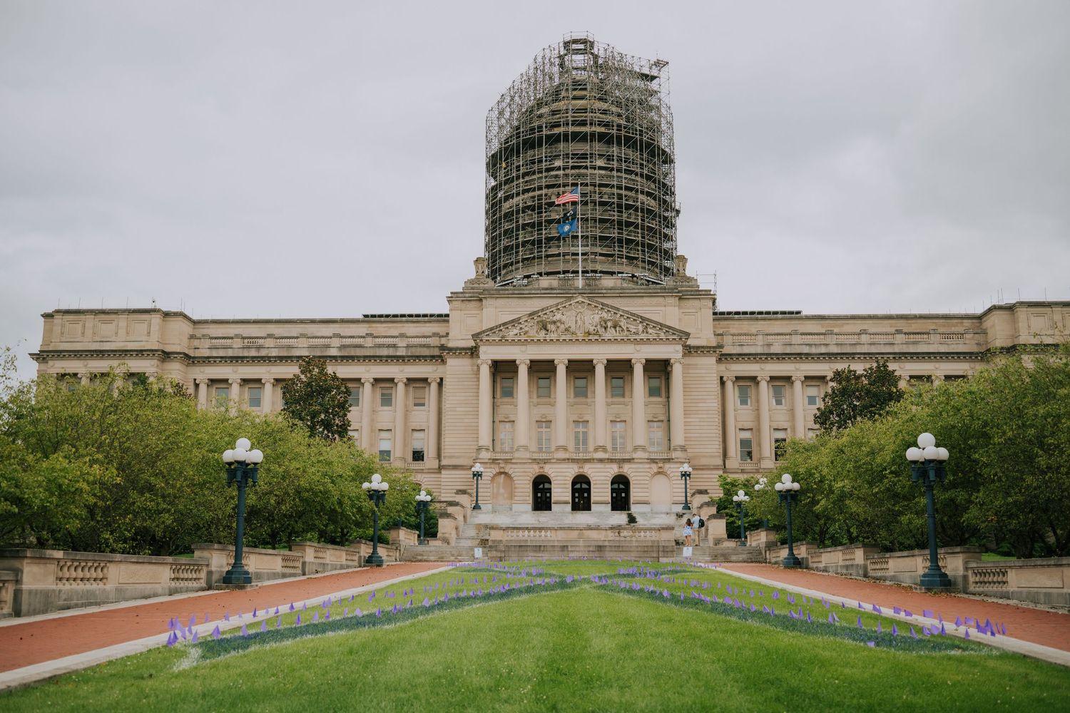 Wide exterior view of a government building with classical architecture and manicured grounds.