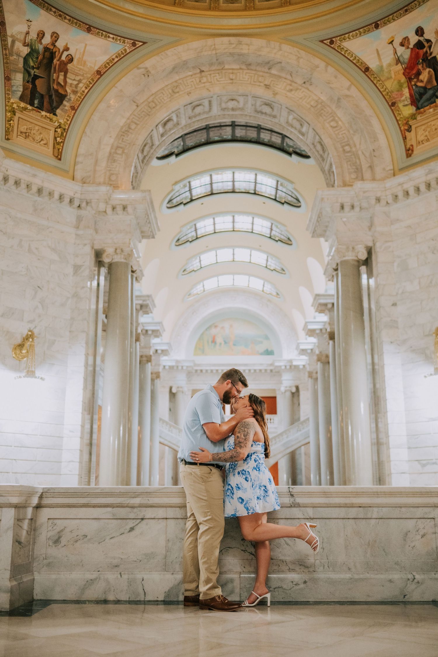 Romantic photoshoot in an ornate marble hall with classical architecture and natural lighting.