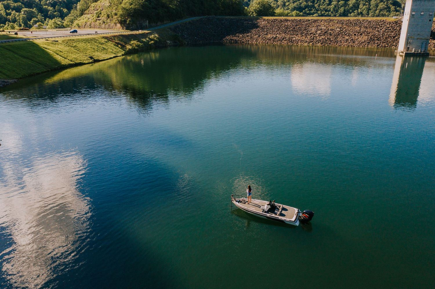 Aerial view of a serene lake with boats and docks surrounded by green landscape.