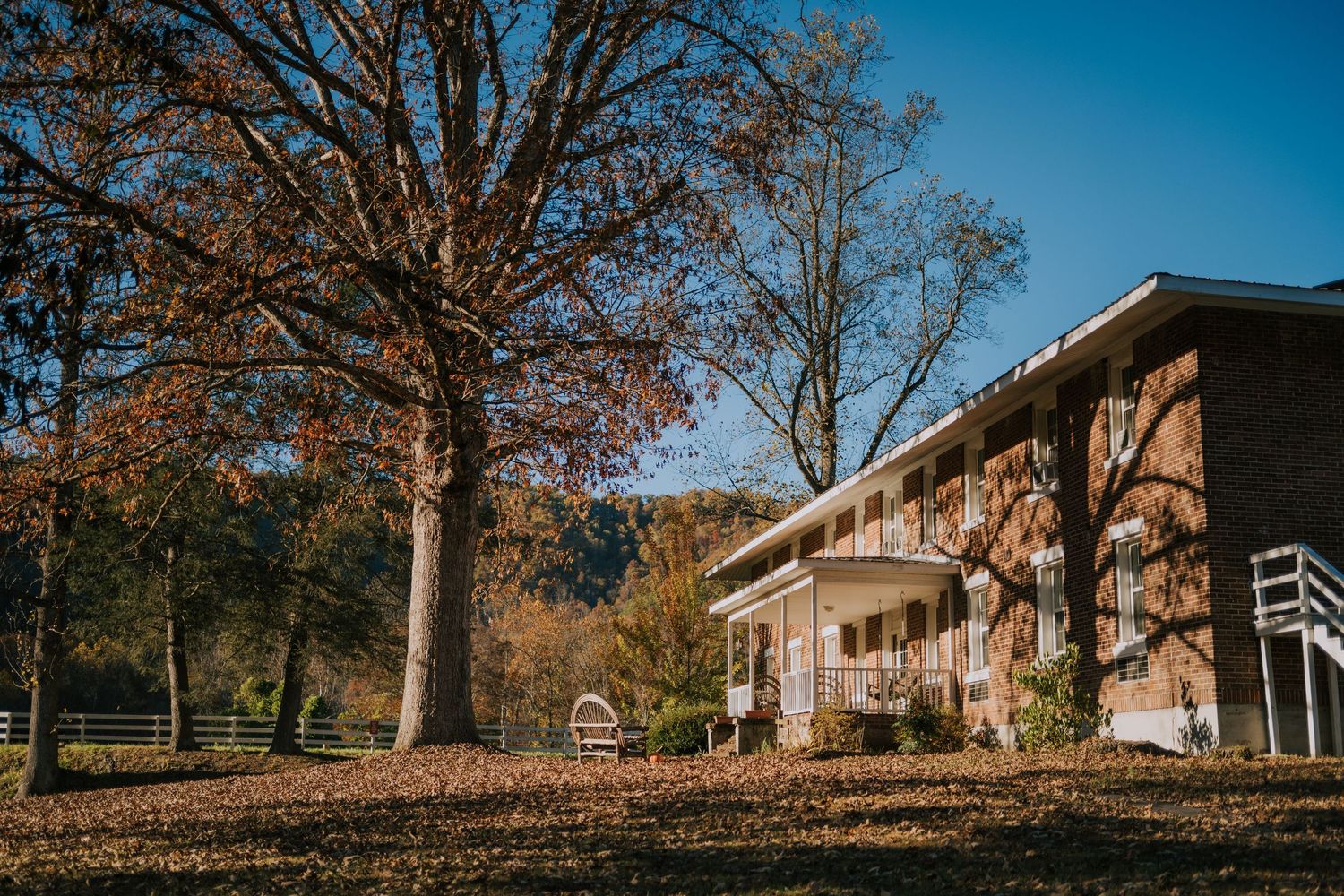 Panoramic view of suburban houses with fall foliage and blue sky in the background.