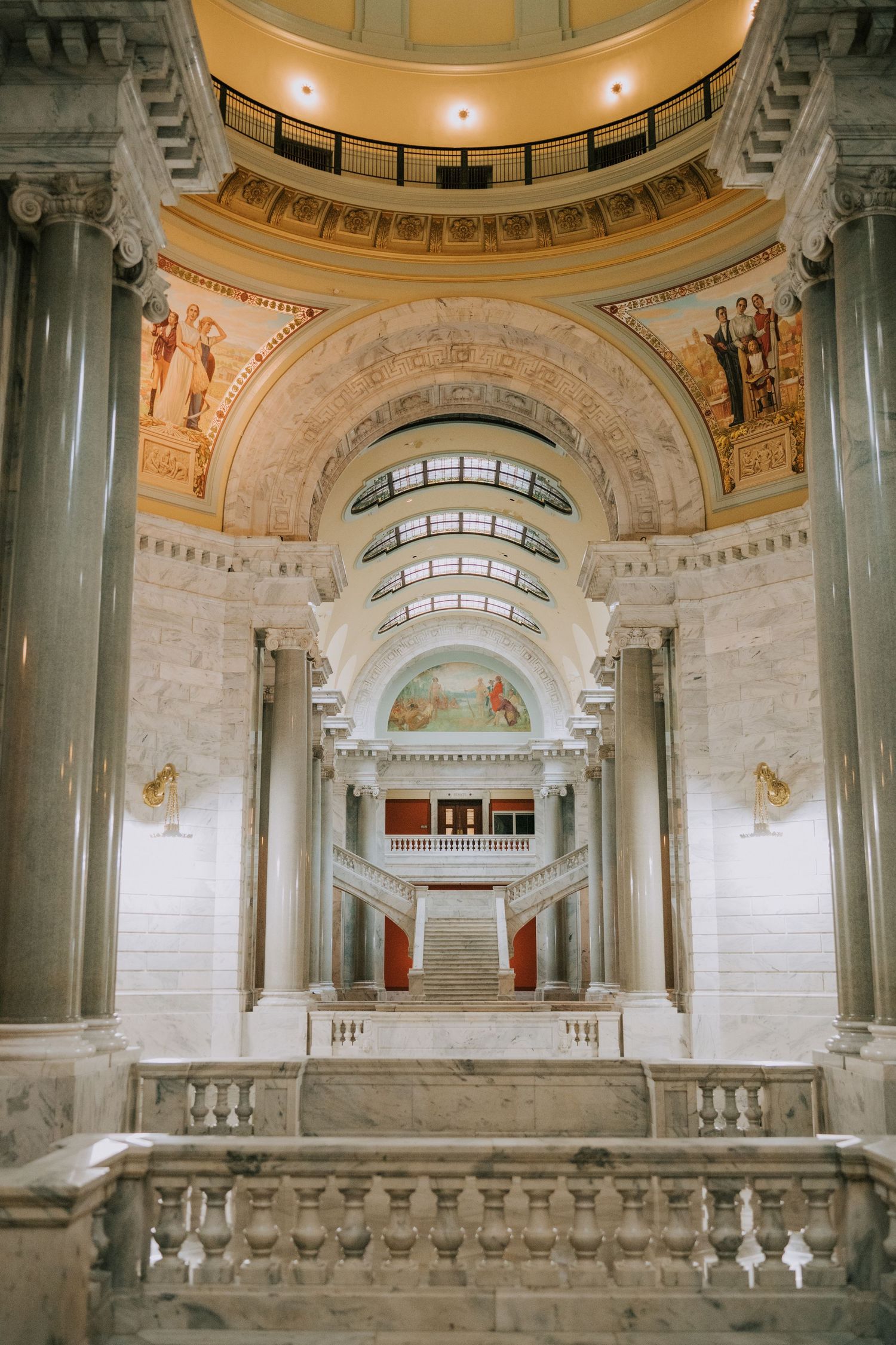 Interior view of an ornate government building with domed ceiling and classical architectural details.