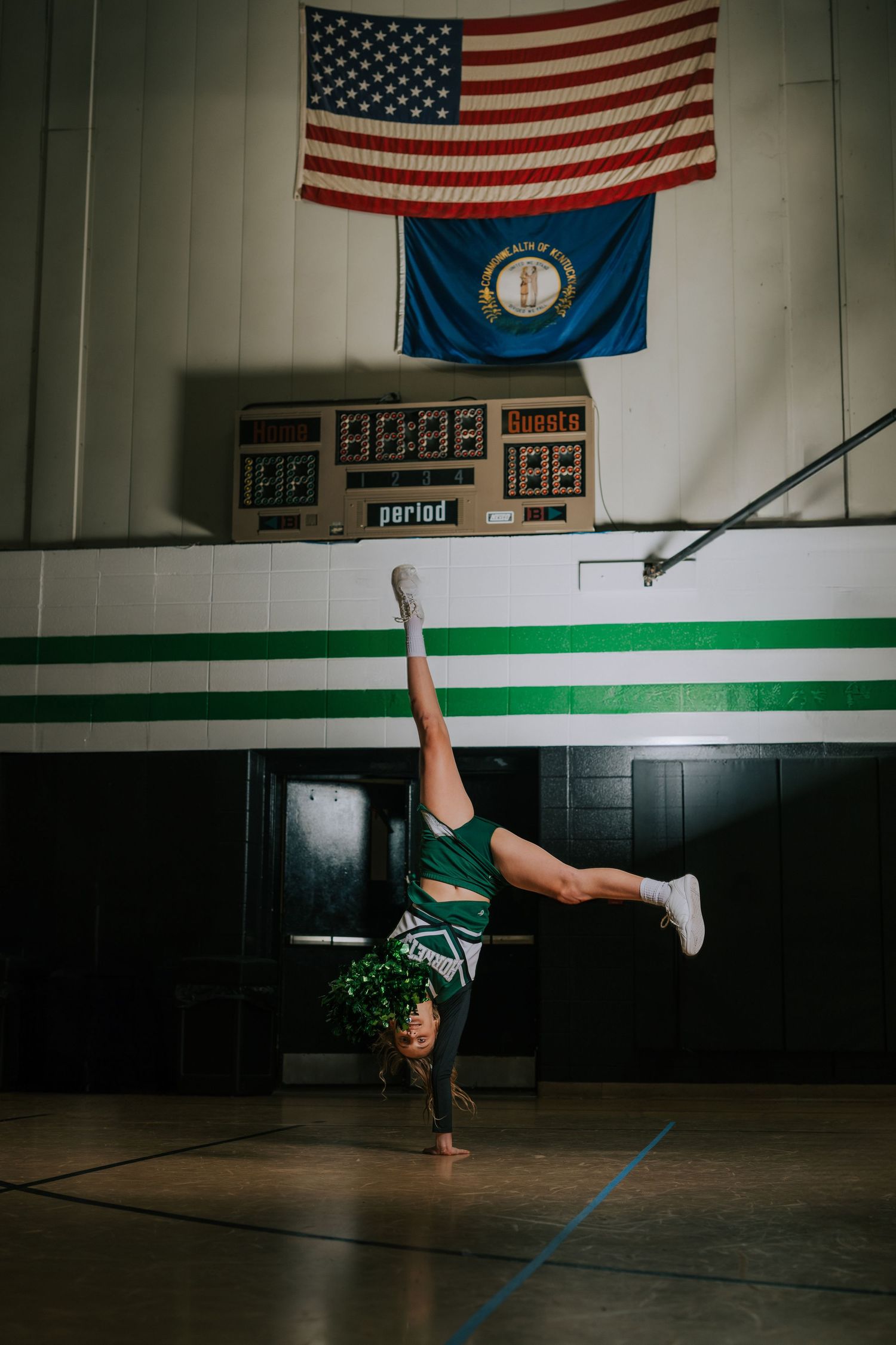 A sequence of four photos showing a person performing a breakdancing move on a gymnasium floor with American flags on the wall.