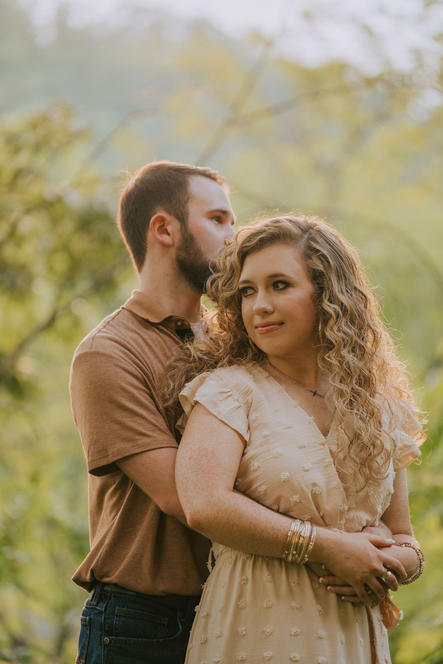 Romantic couple in casual attire sharing tender moments outdoors.