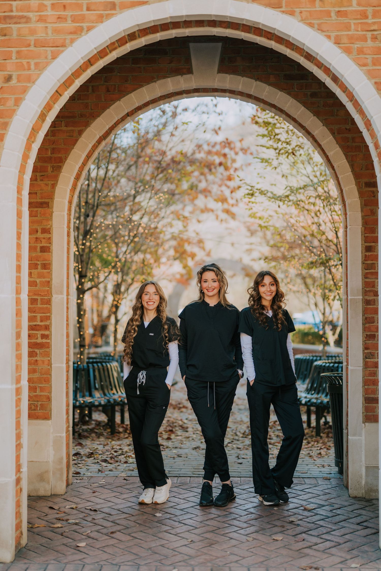 A group walking through brick archways in matching black outfits.