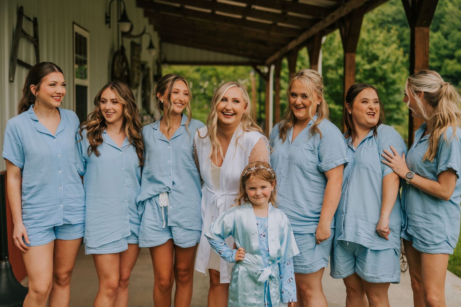 Wedding party wearing matching light blue button-down shirts poses together during pre-ceremony preparations.
