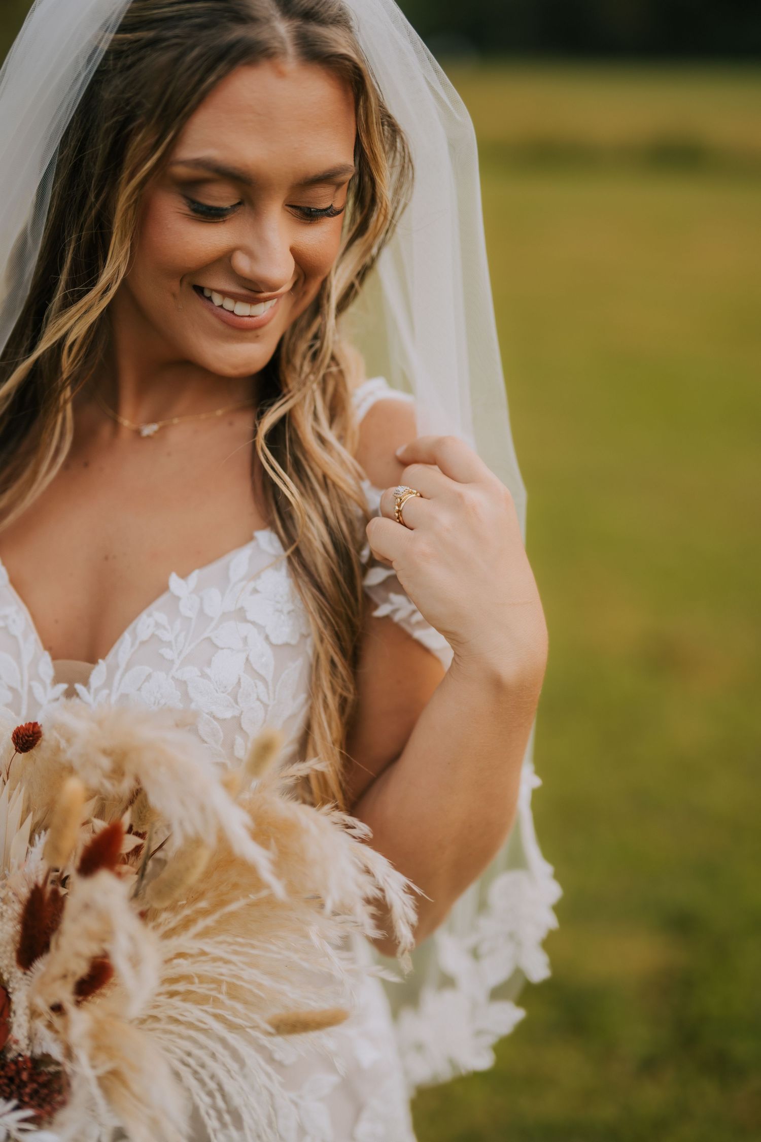 Close-up details of lace wedding dress with dried floral accents.