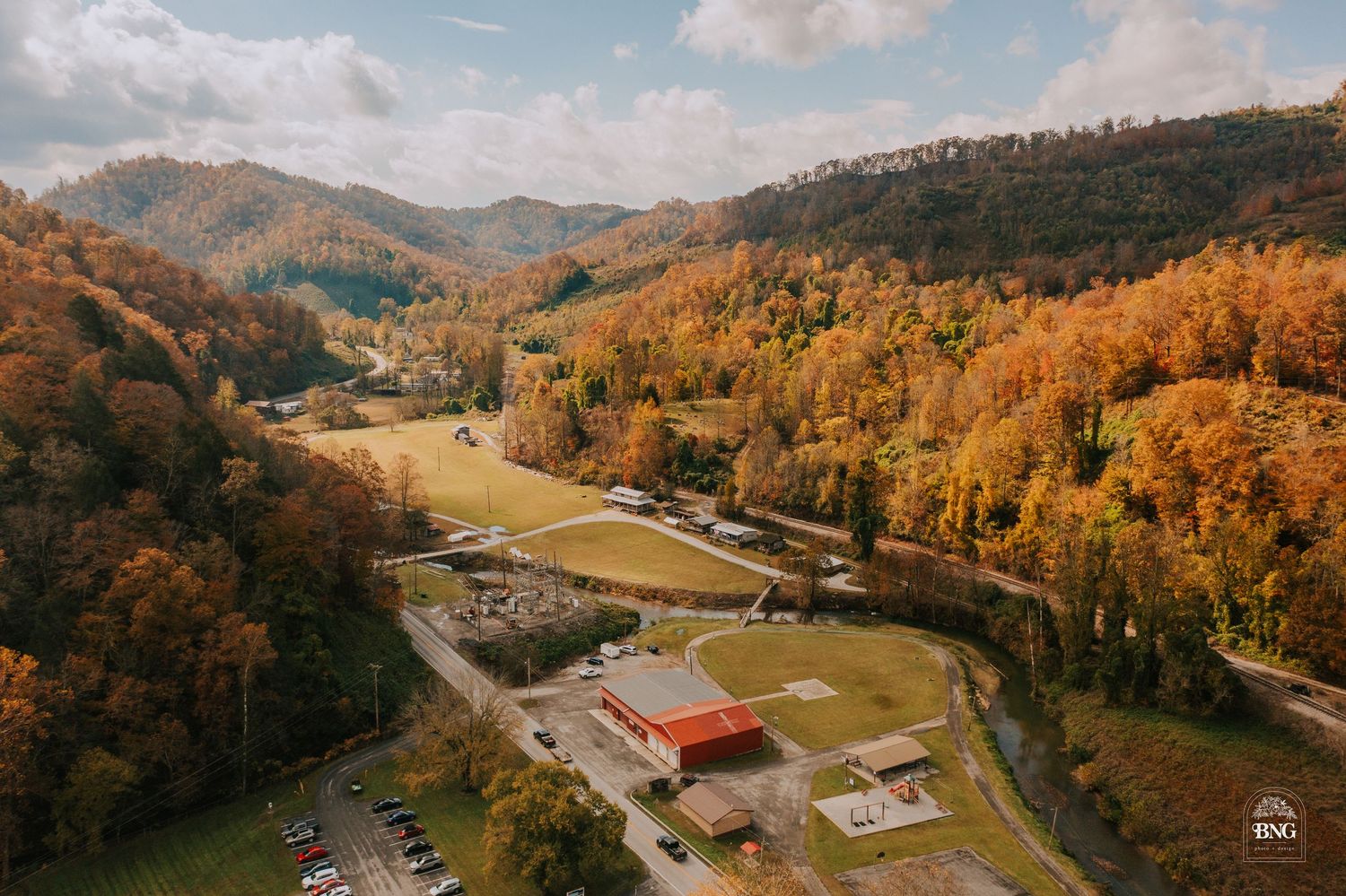 Aerial panorama of winding road through mountainous autumn landscape.