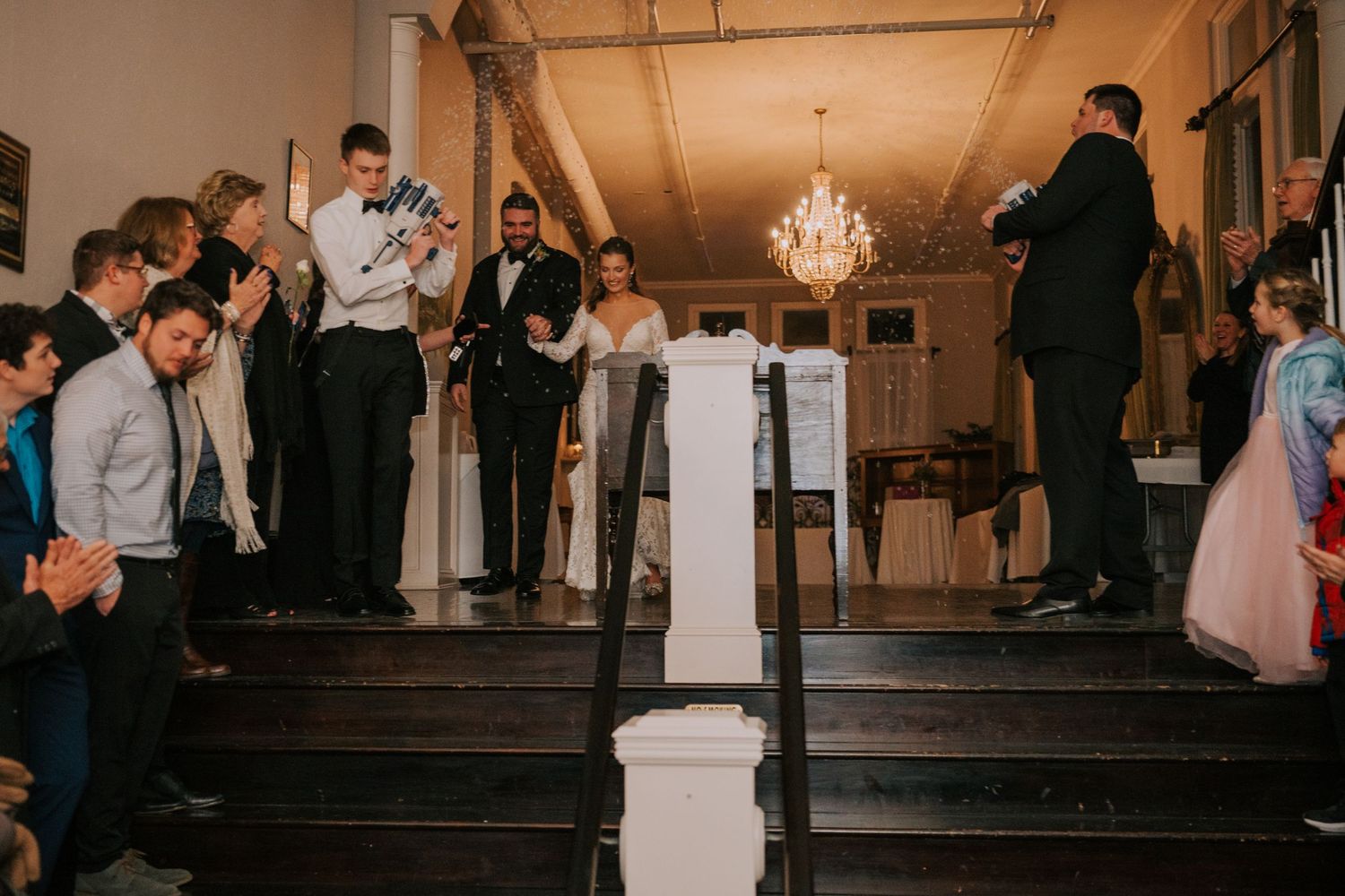 A group of people gathered on elegant stairs during what appears to be a formal event or celebration.