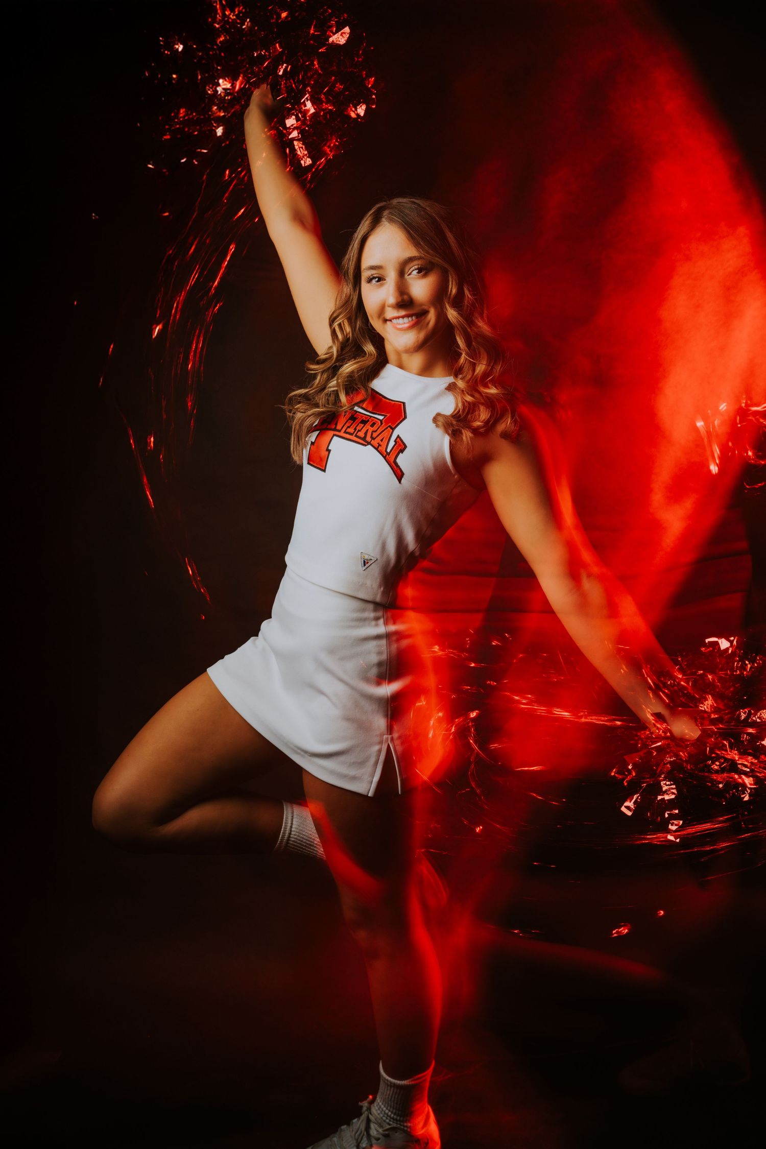 Dancer in white outfit performs dynamic movements against dramatic red lighting and smoke effects.