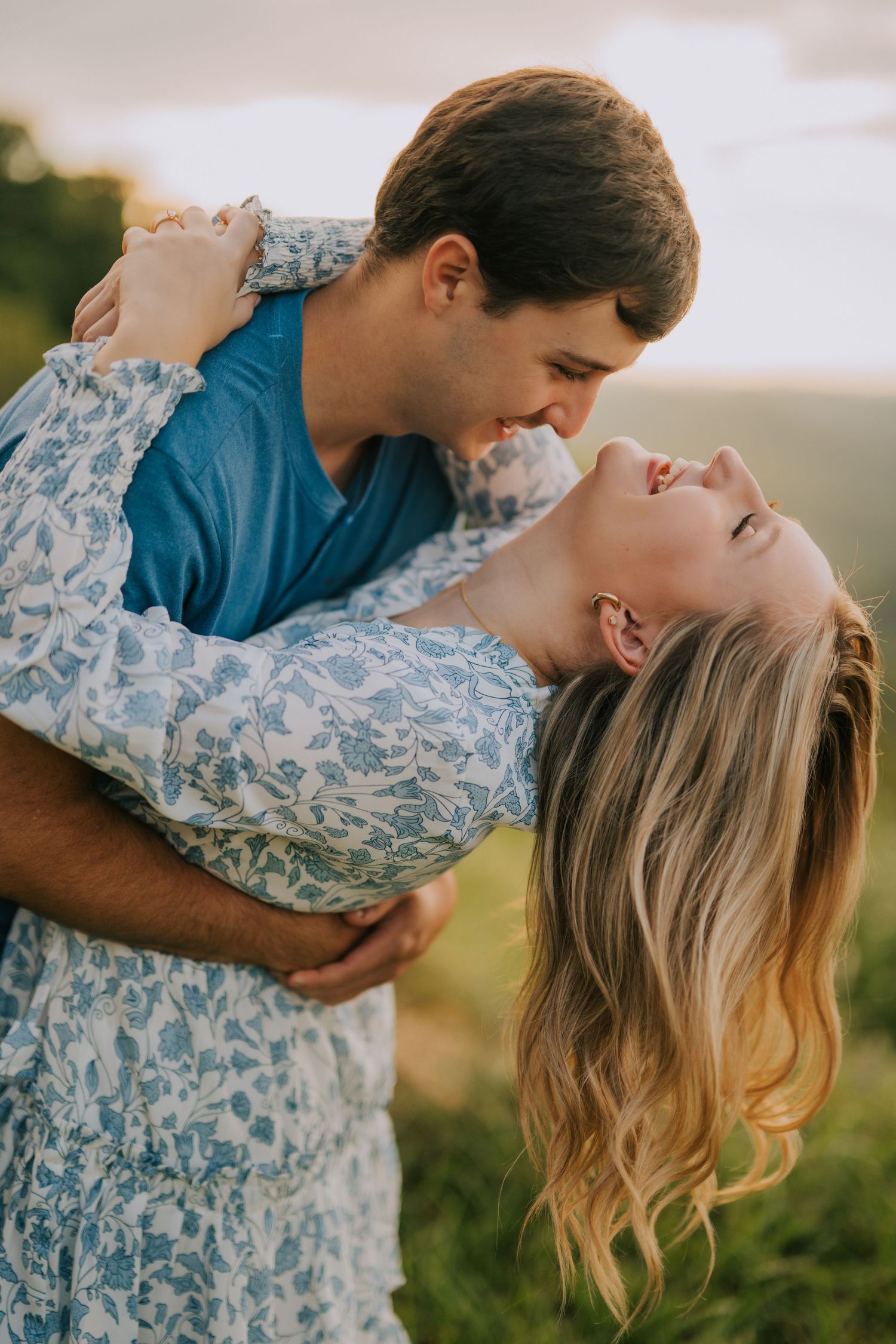Romantic outdoor photoshoot in a meadow with soft golden hour lighting.
