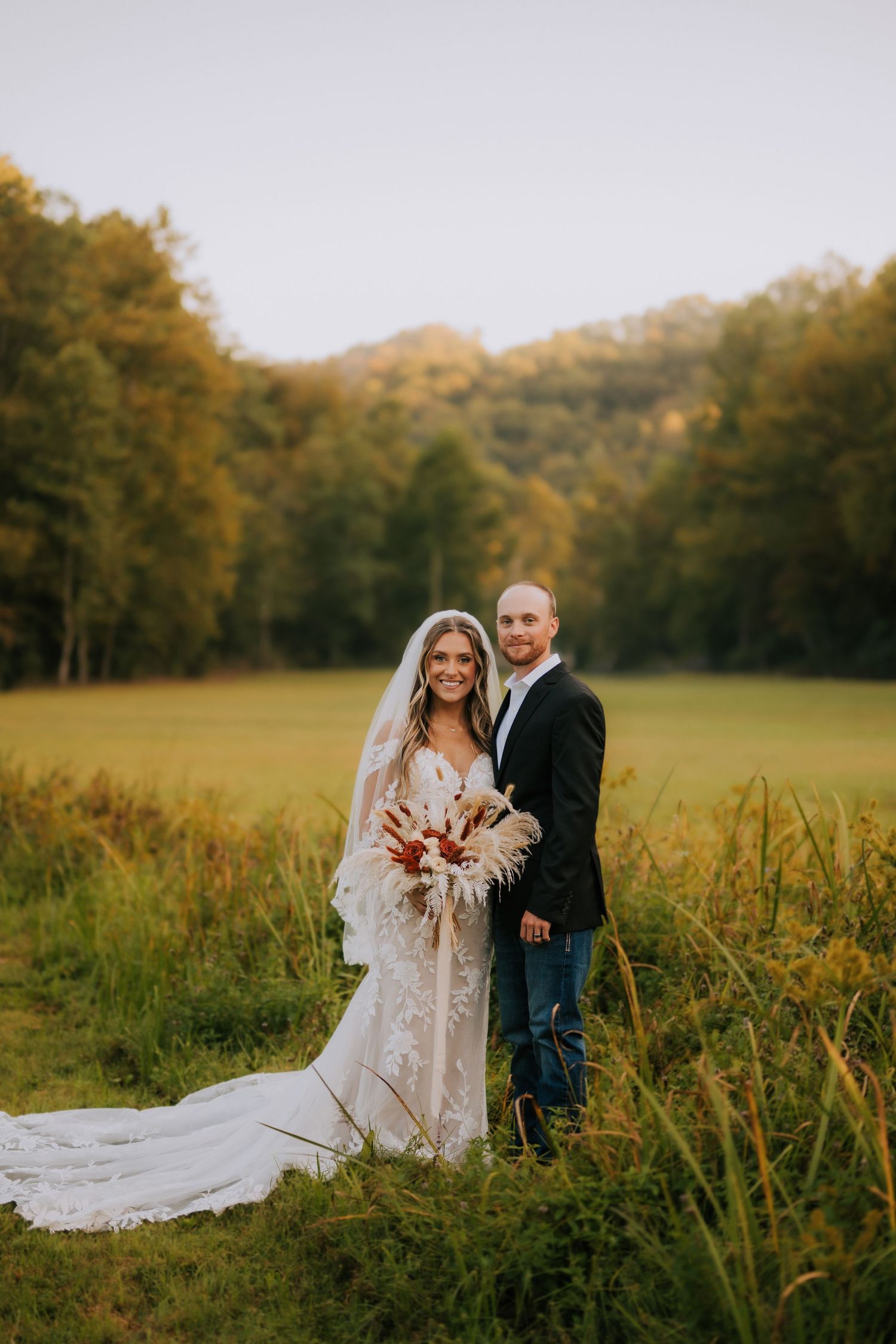 Romantic autumn wedding portraits in a golden field at sunset.