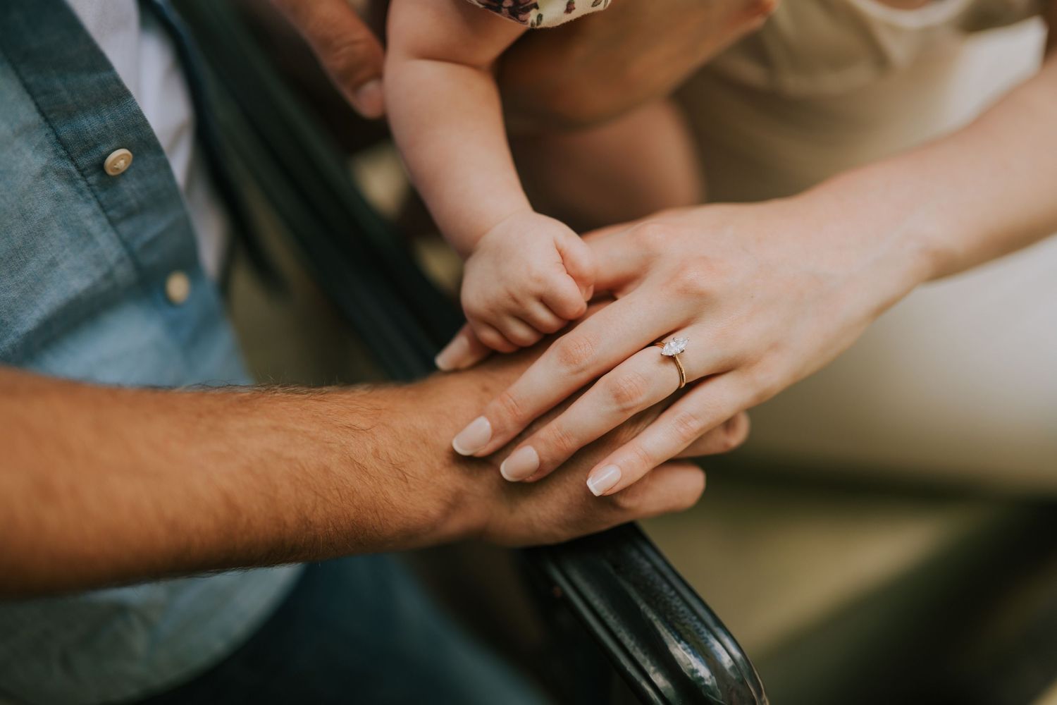 Close-up shot of hands with rings being held together in an intimate moment.