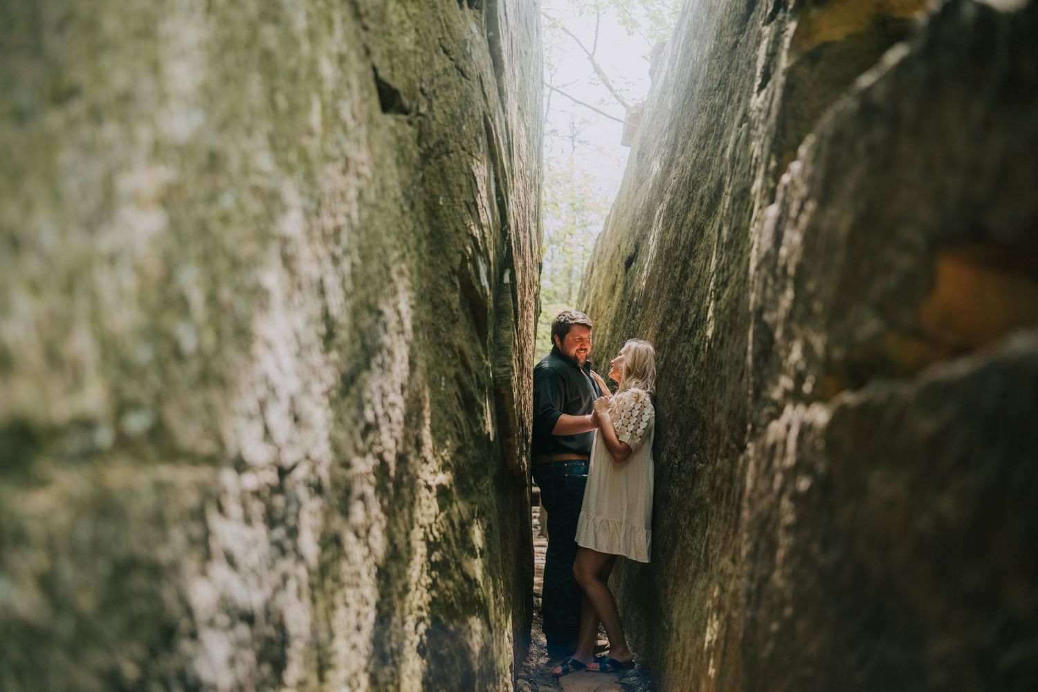Dramatic photo taken between narrow rock formations in natural outdoor setting.