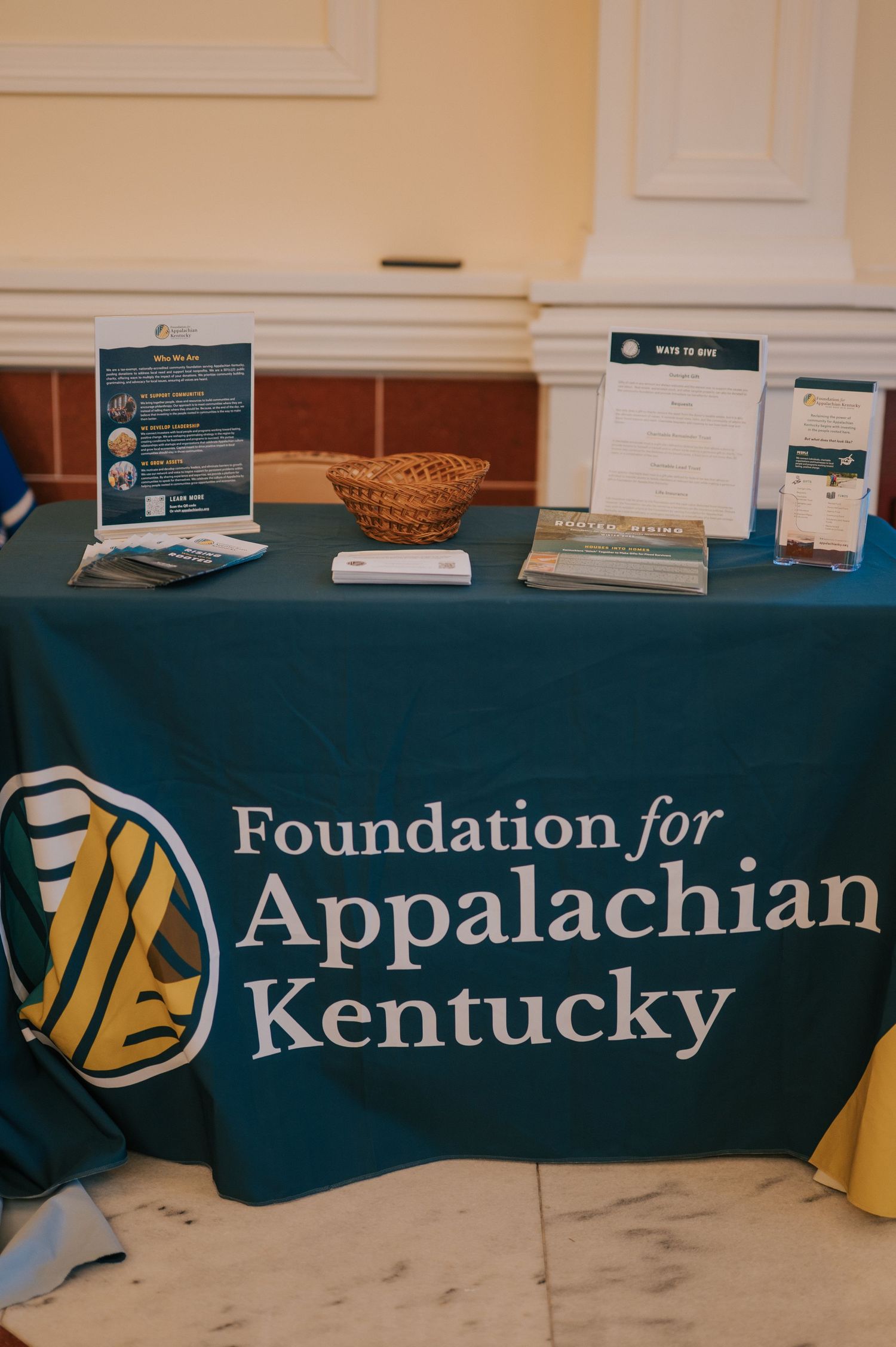 A Foundation for Appalachian Kentucky display table with teal tablecloth, informational materials and woven basket.