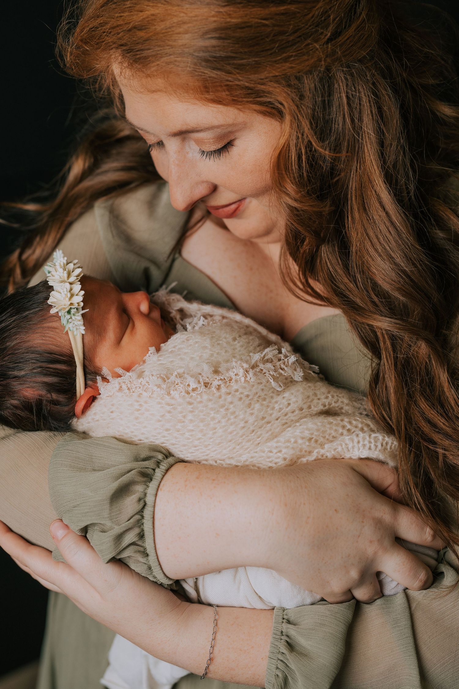 Tender moment between parent and baby in soft, natural lighting.