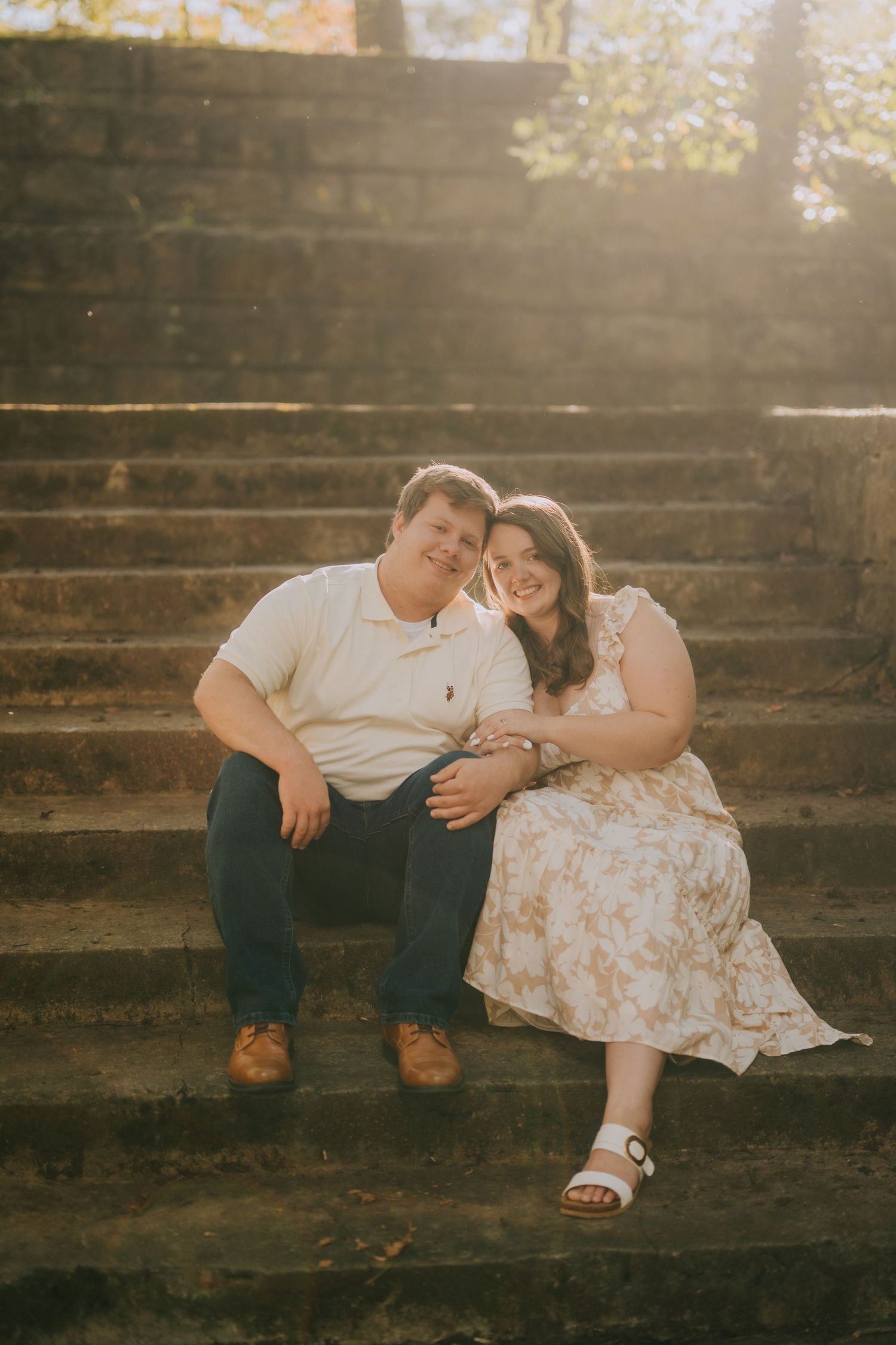 A couple relaxing together on wooden steps during a romantic outdoor photoshoot.