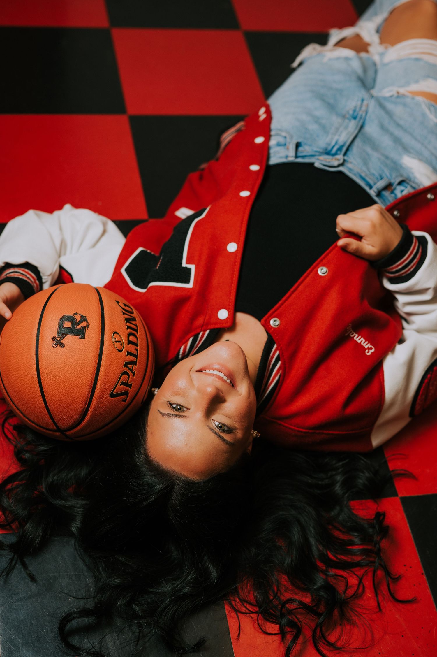 Creative basketball themed photoshoot on red and black checkered floor.