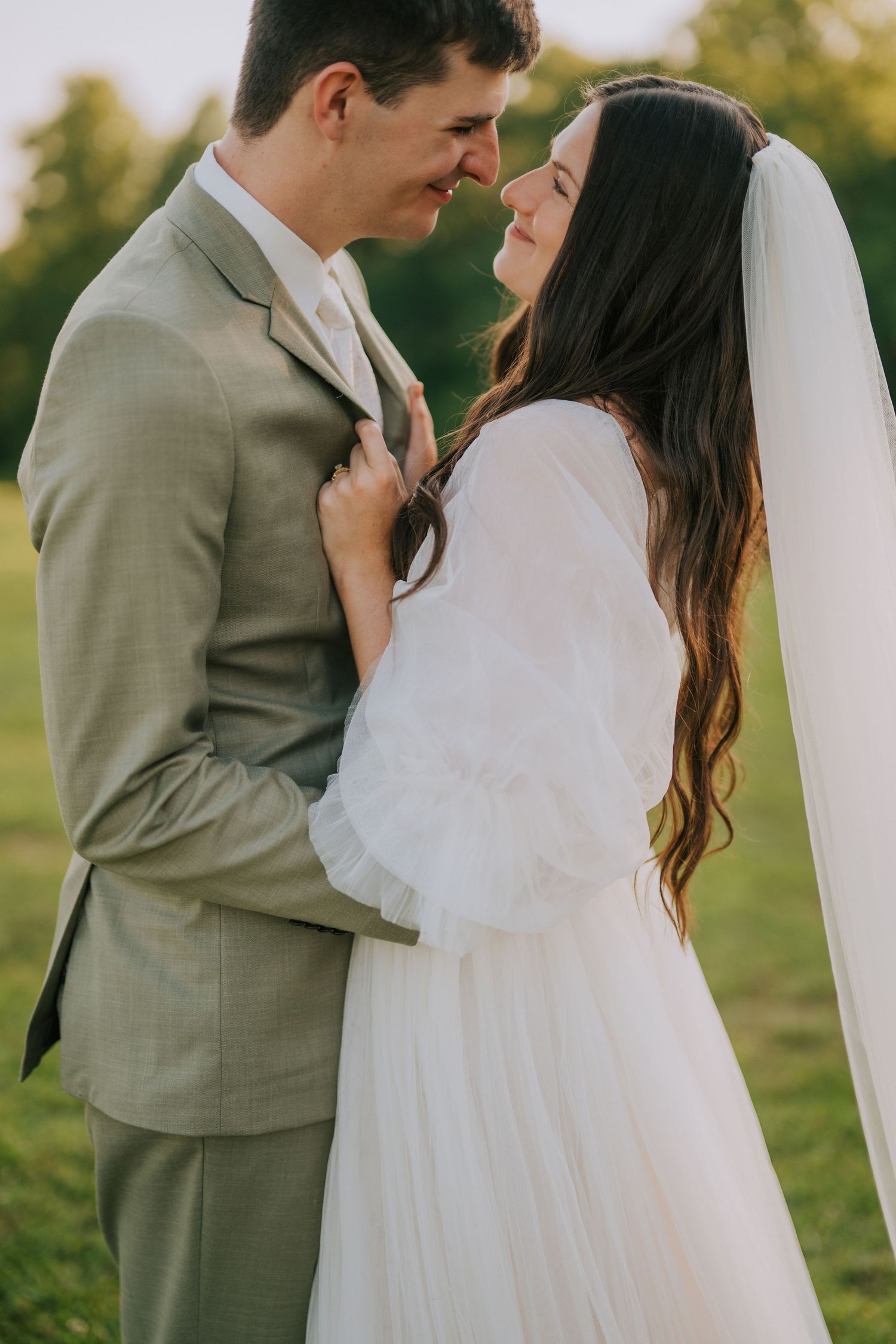 Romantic outdoor wedding portraits captured during golden hour in a garden setting.