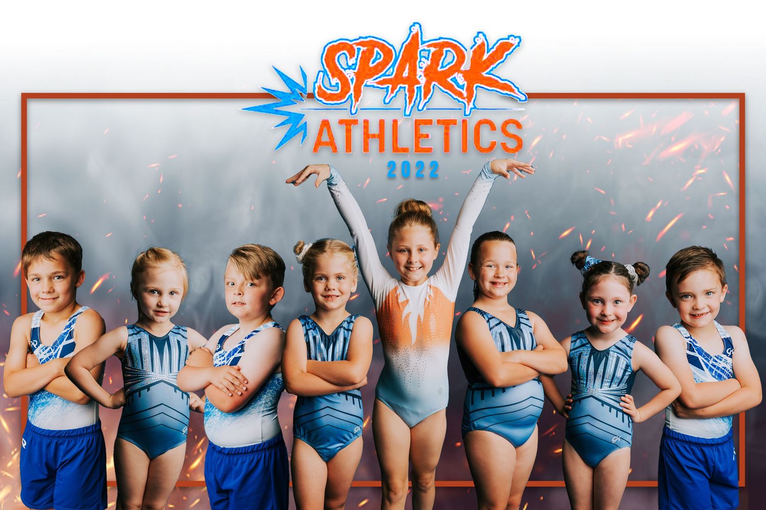 Youth swim team members in blue uniforms pose together in a fun and energetic group photo.